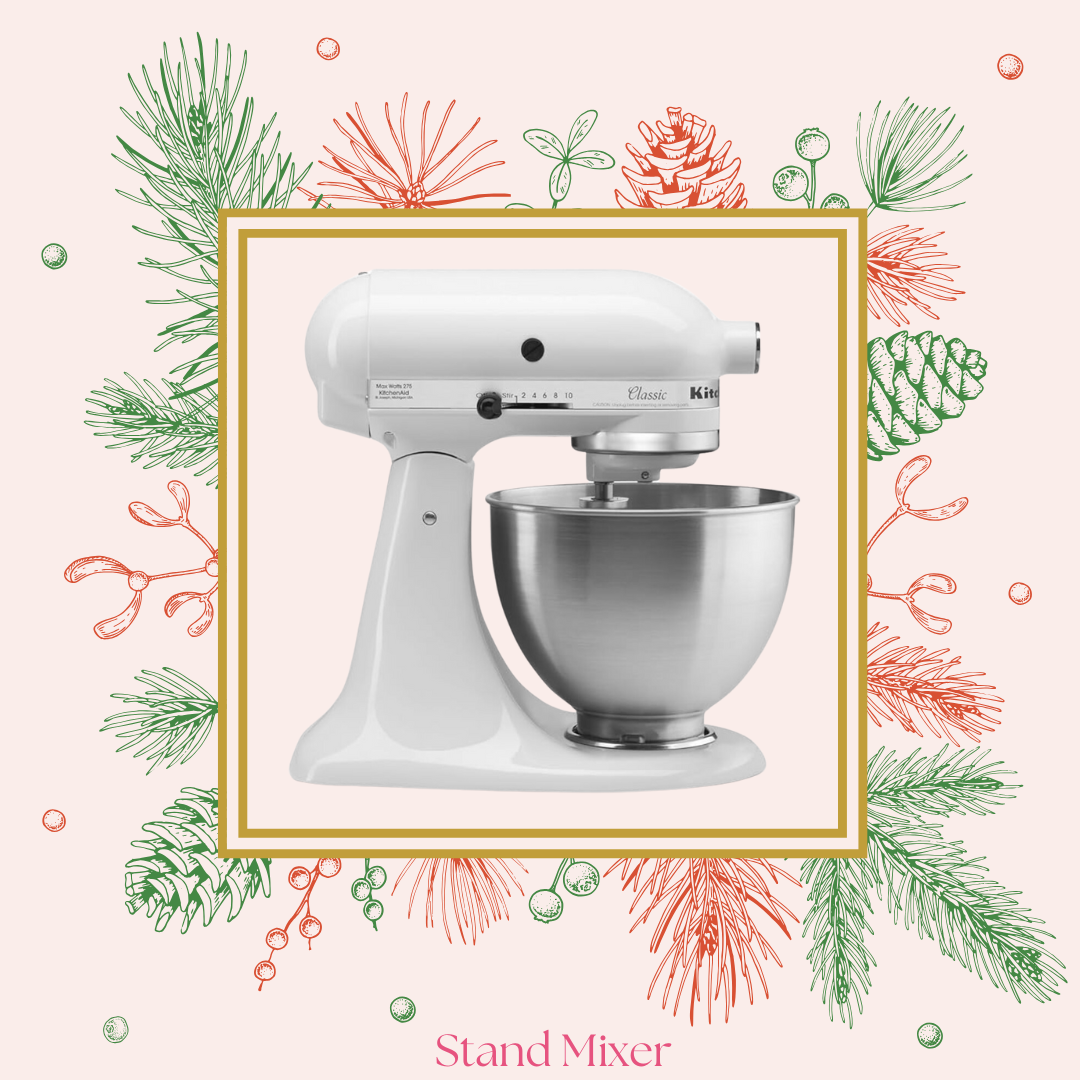 A white stand mixer with a stainless steel mixing bowl on a pink background with green and red holiday-themed pine branches and berries, labeled 'Stand Mixer'.
