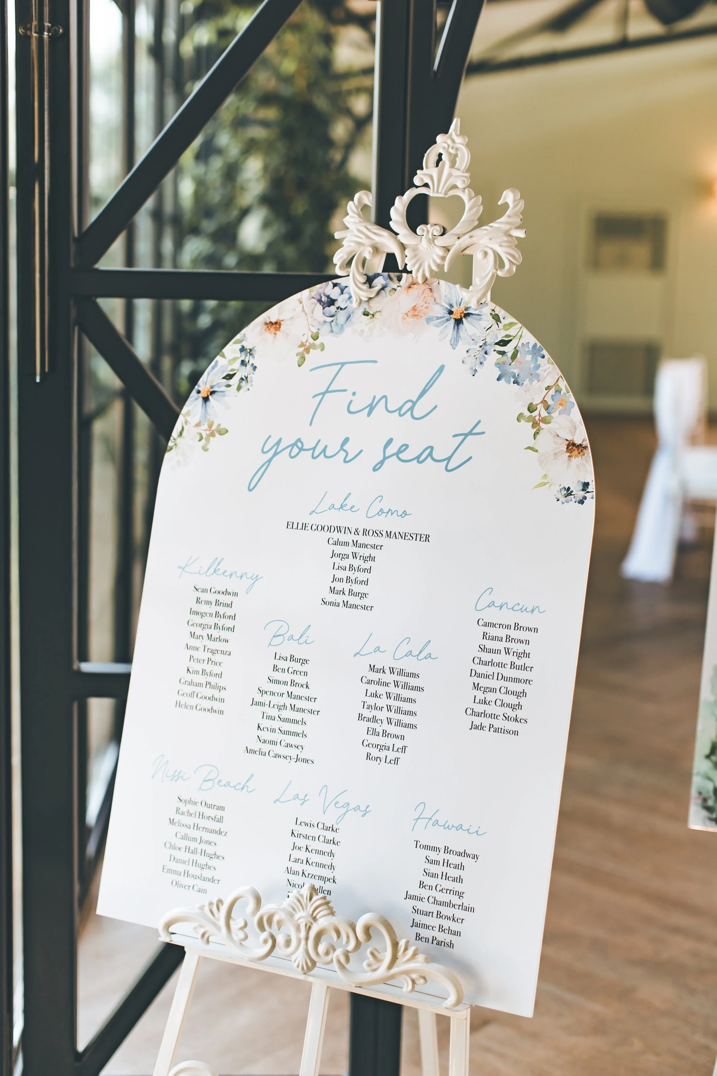 An arched wedding table plan with blue and white florals. Image by Shianne Mercer Photography