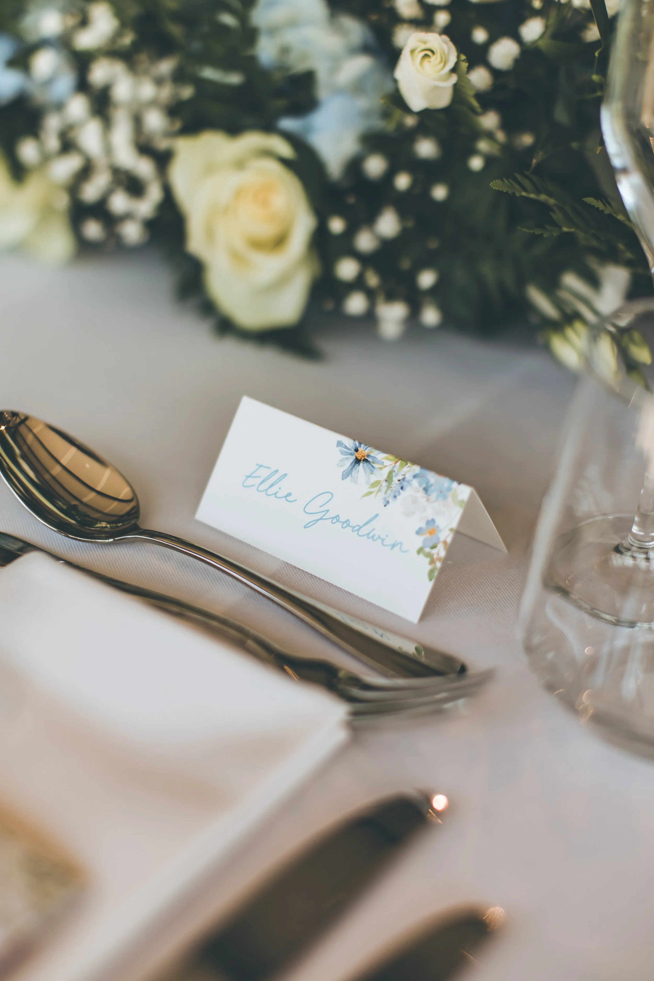 A folded wedding place card on table. Image by Shianne Mercer Photography