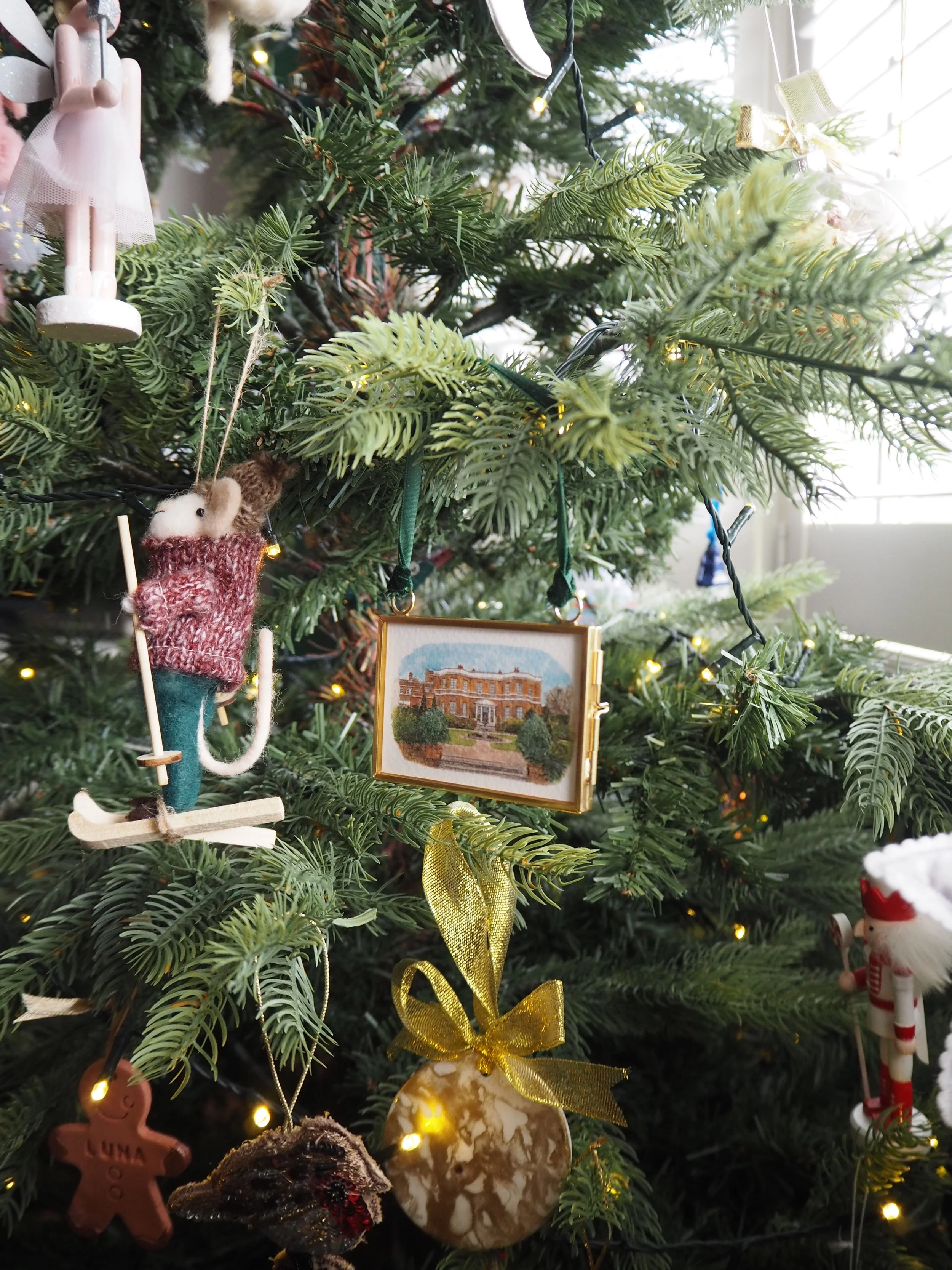 a small hanging frame christmas tree decoration featuring a watercolour illustration of Burloes Hall