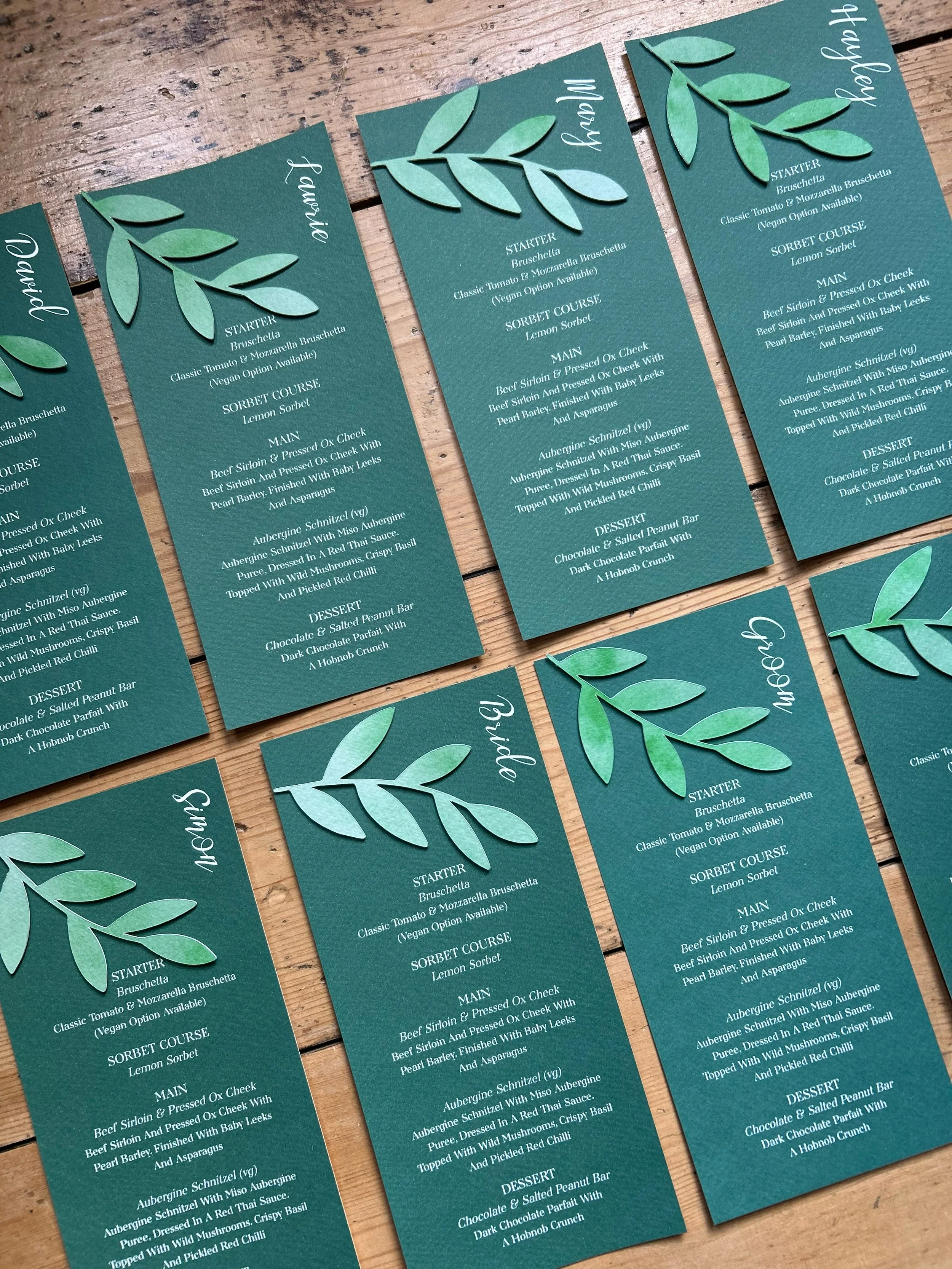 Bespoke cut green leaf personalised wedding menus. Green foliage stationery. Cricut wedding stationery. Bespoke wedding stationery. Forest green wedding menus. 3D wedding menus. Forest green wedding theme.