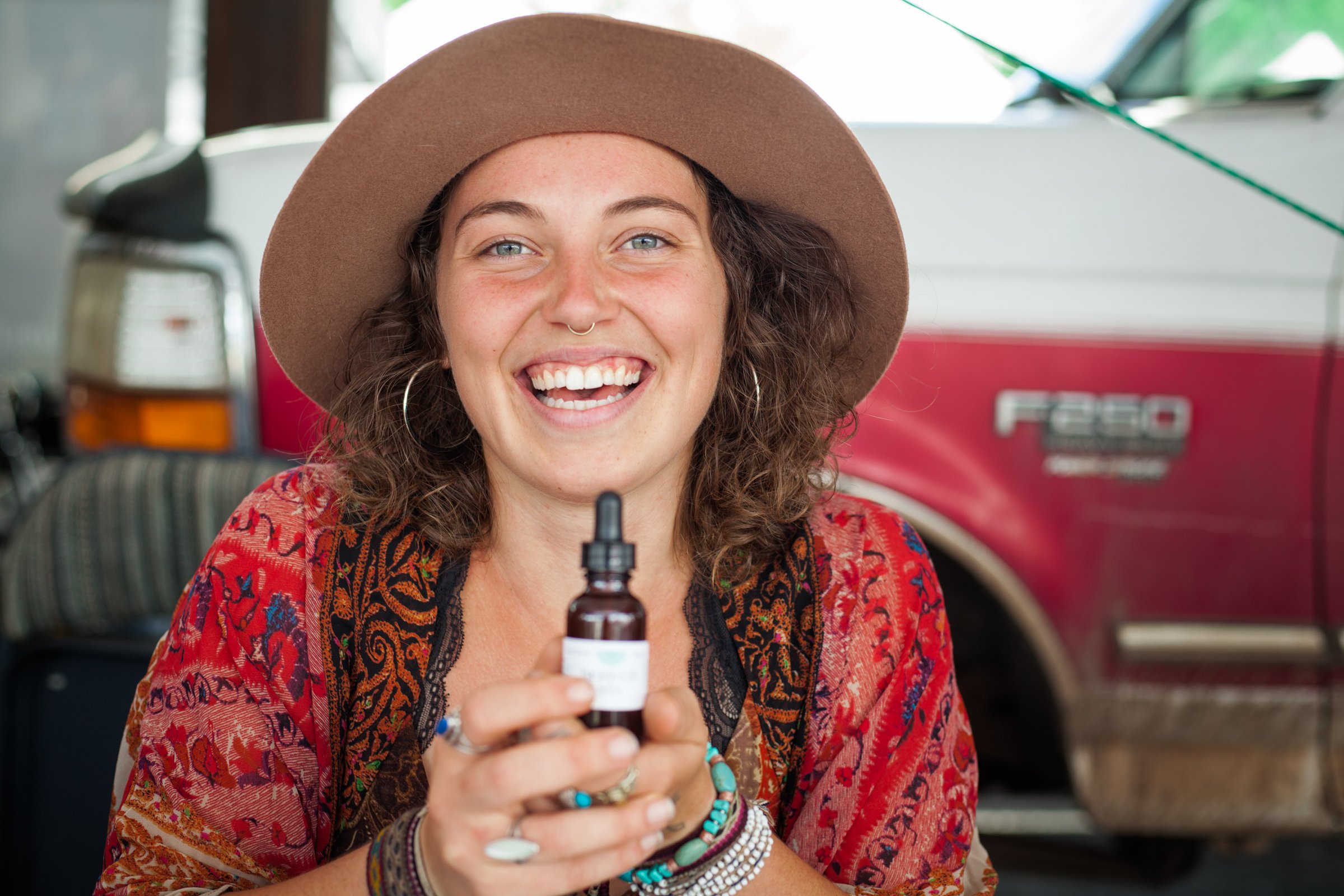 Amara Stark smiling and holding an herbal tincture.