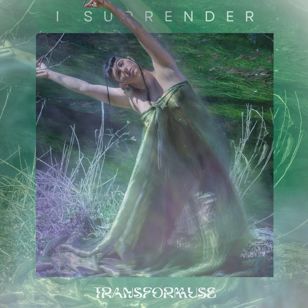 Ayam in a green dress, is lying in a pond with water up to her shoulders. She has her arms extended and is looking up with her eyes closed. The Single title 'I SURRENDER' is at the top of the image.