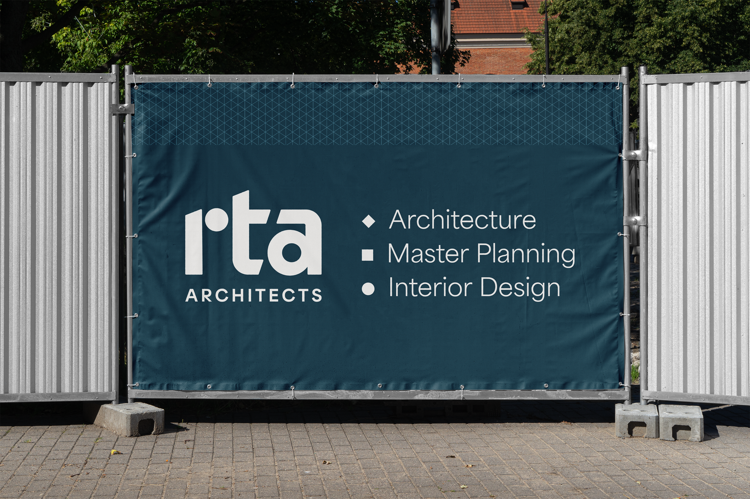 A construction fence with a large sign advertising an architecture firm named 'rta Architects'. The sign lists services: Architecture, Master Planning, Interior Design.