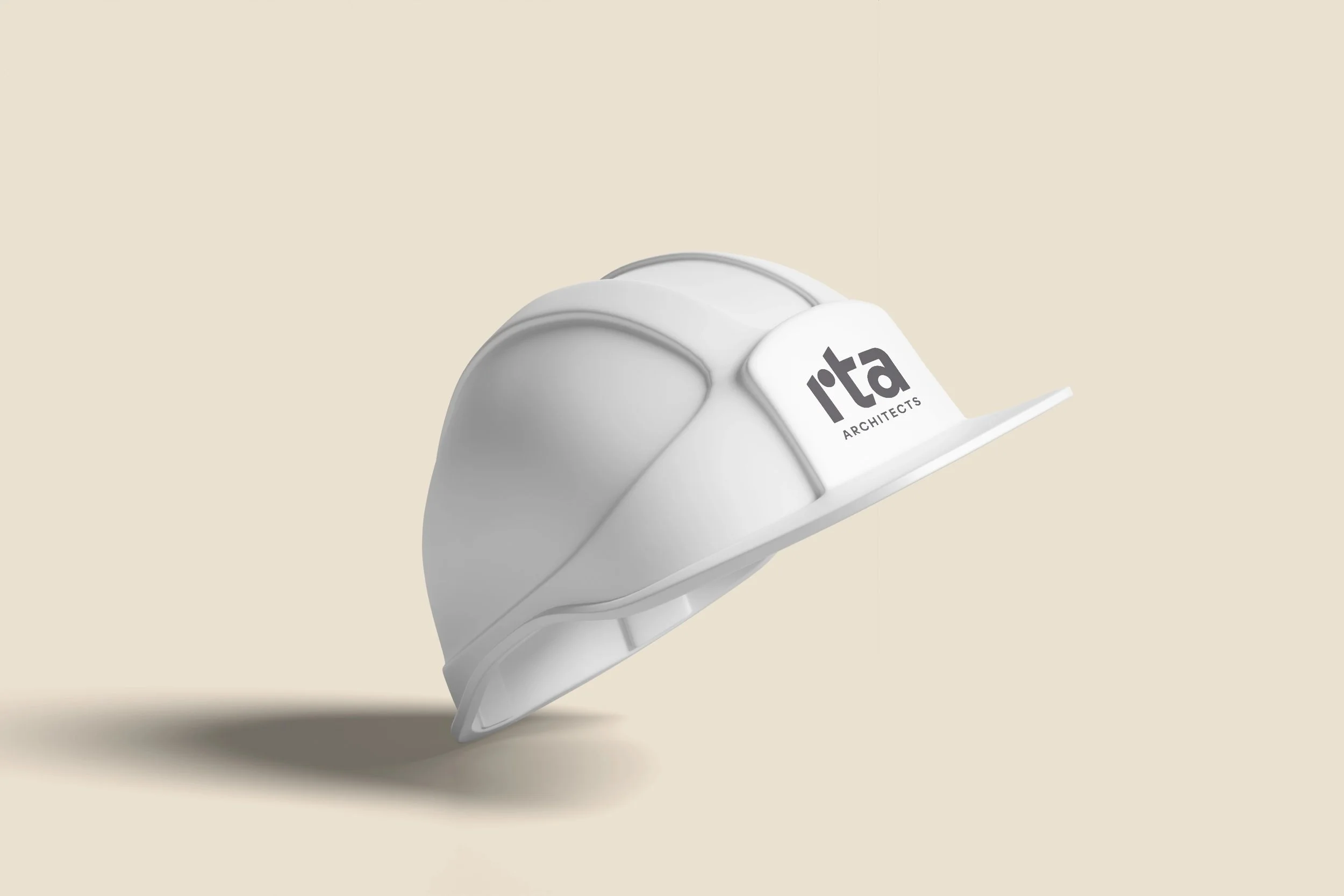 A white construction helmet with a logo that reads 'rta ARCHITECTS' on the front, floating against a beige background.