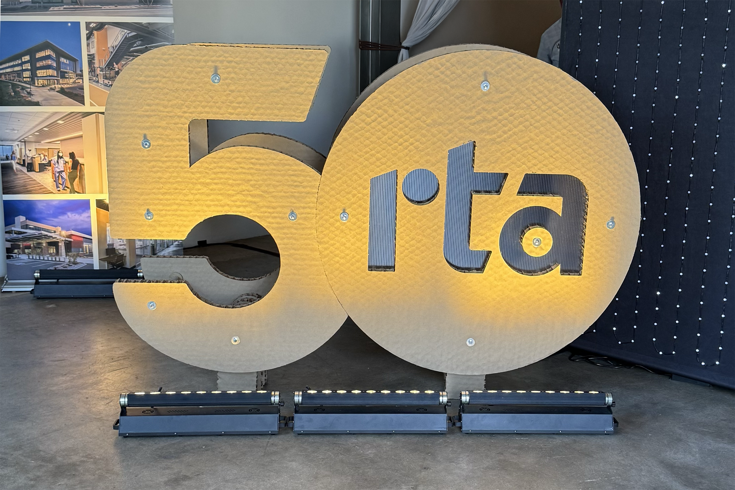Large illuminated sign with the number 50 and the word ' Italia' in stylized letters, placed indoors at a promotional or celebratory event.