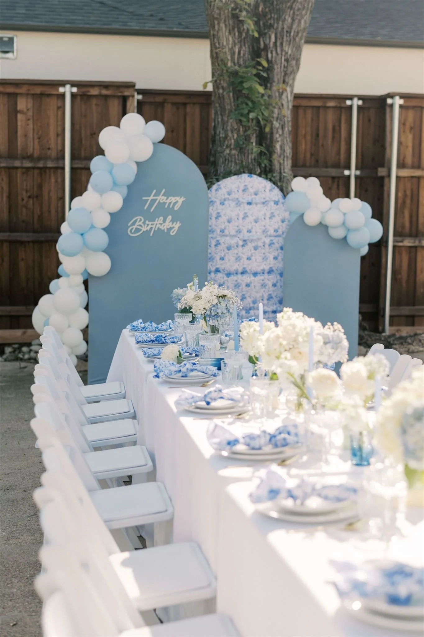 Blue and floral arched backdrop for a party styled by Wanderlust Picnics