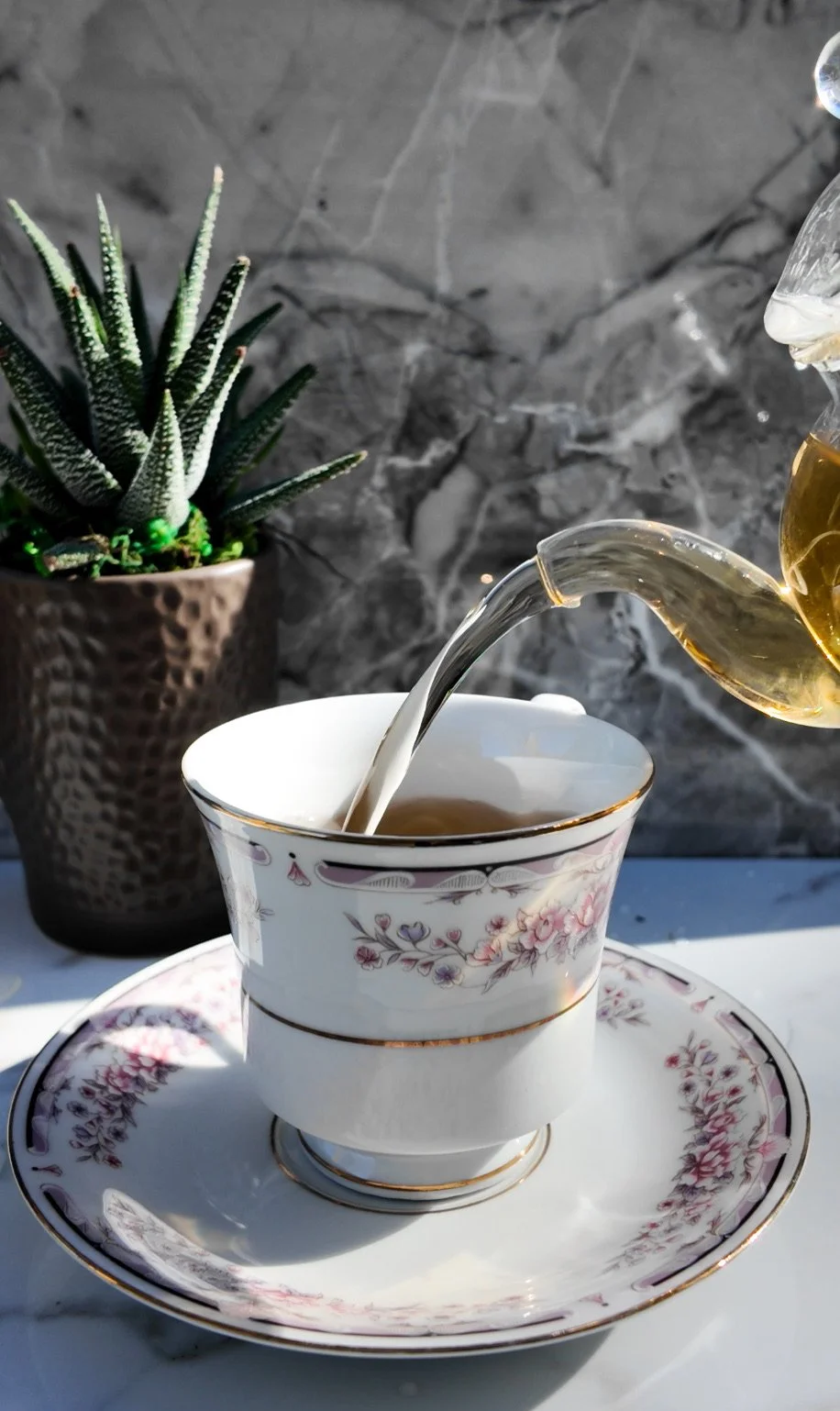 Tea being poured into a porcelain tea cup