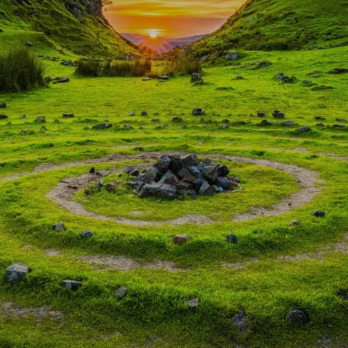 a pile of rocks in a meadow with a sunset in the background | The Witch's Therapist | London Ontario Holistic Therapy