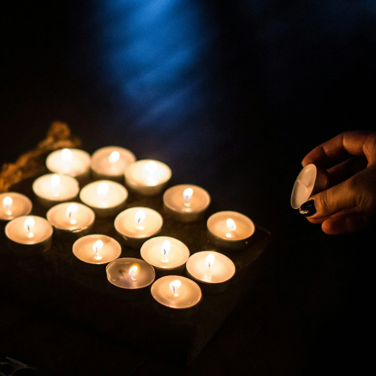 Several lit candles burning in a dark environment. | The Witch's Therapist | Holistic Psychotherapy in London Ontario