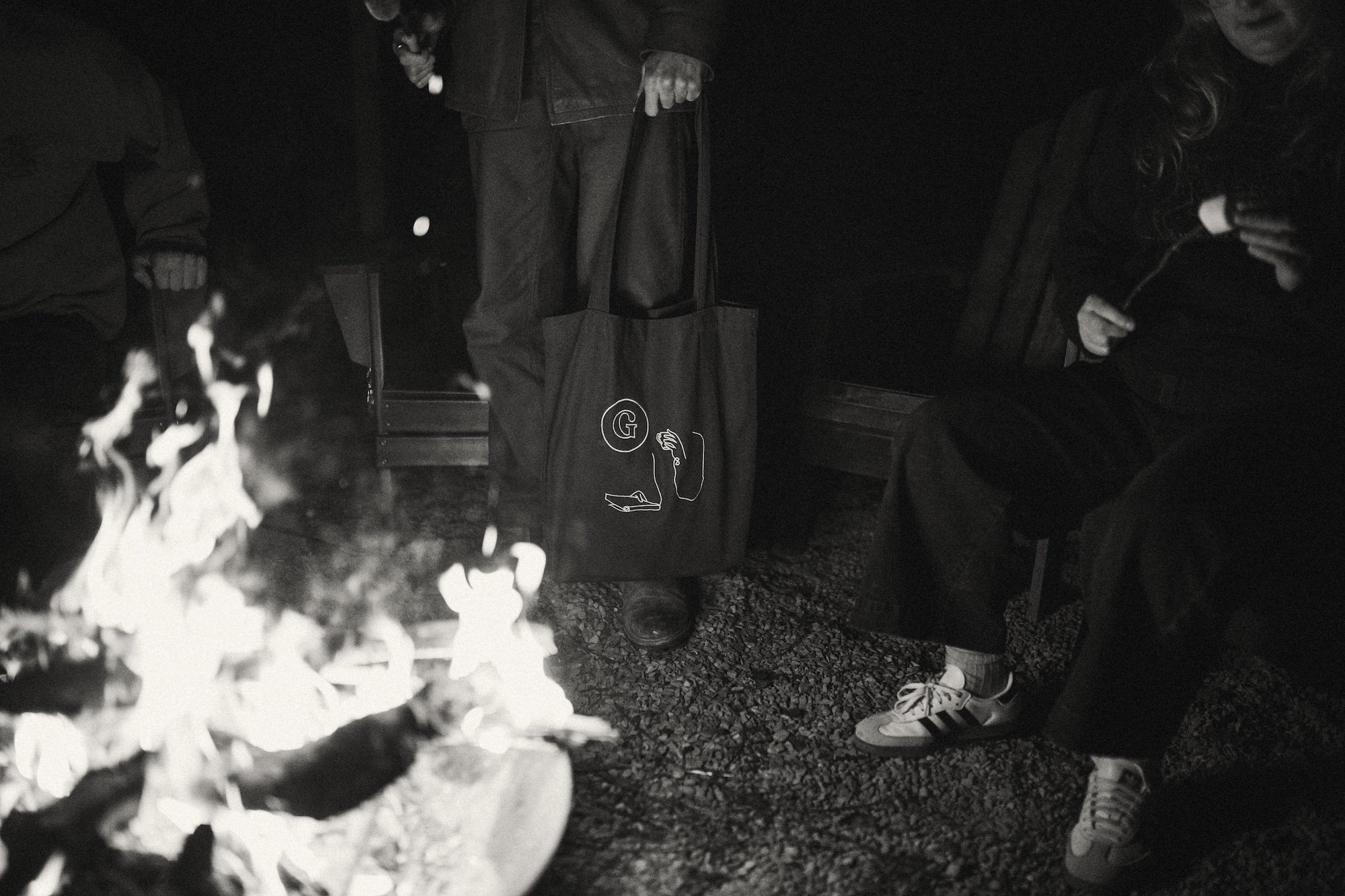 A Gilliam Writers Group tote held beside the glowing campfire.