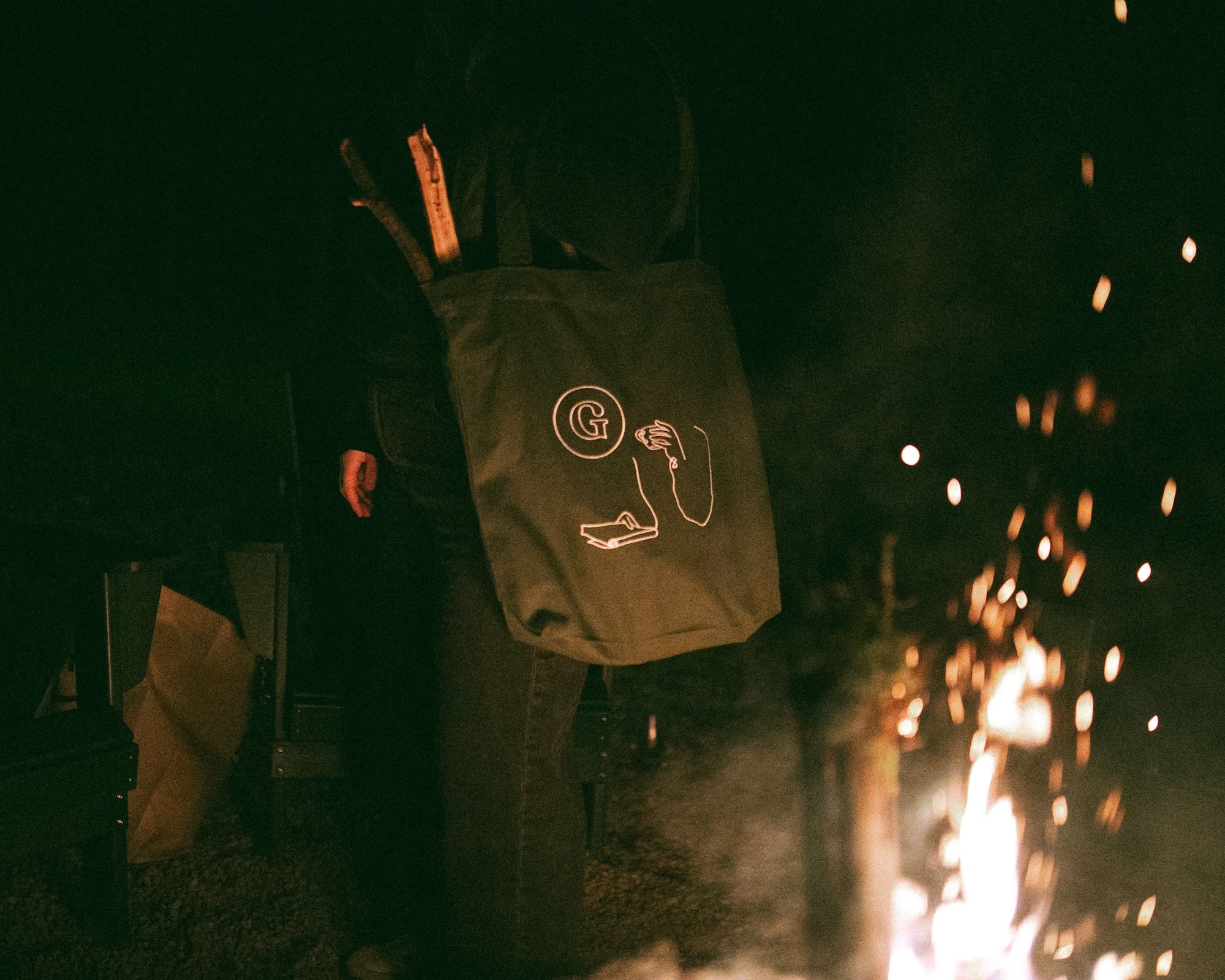 A Gilliam Writers Group tote carries firewood toward the bonfire.