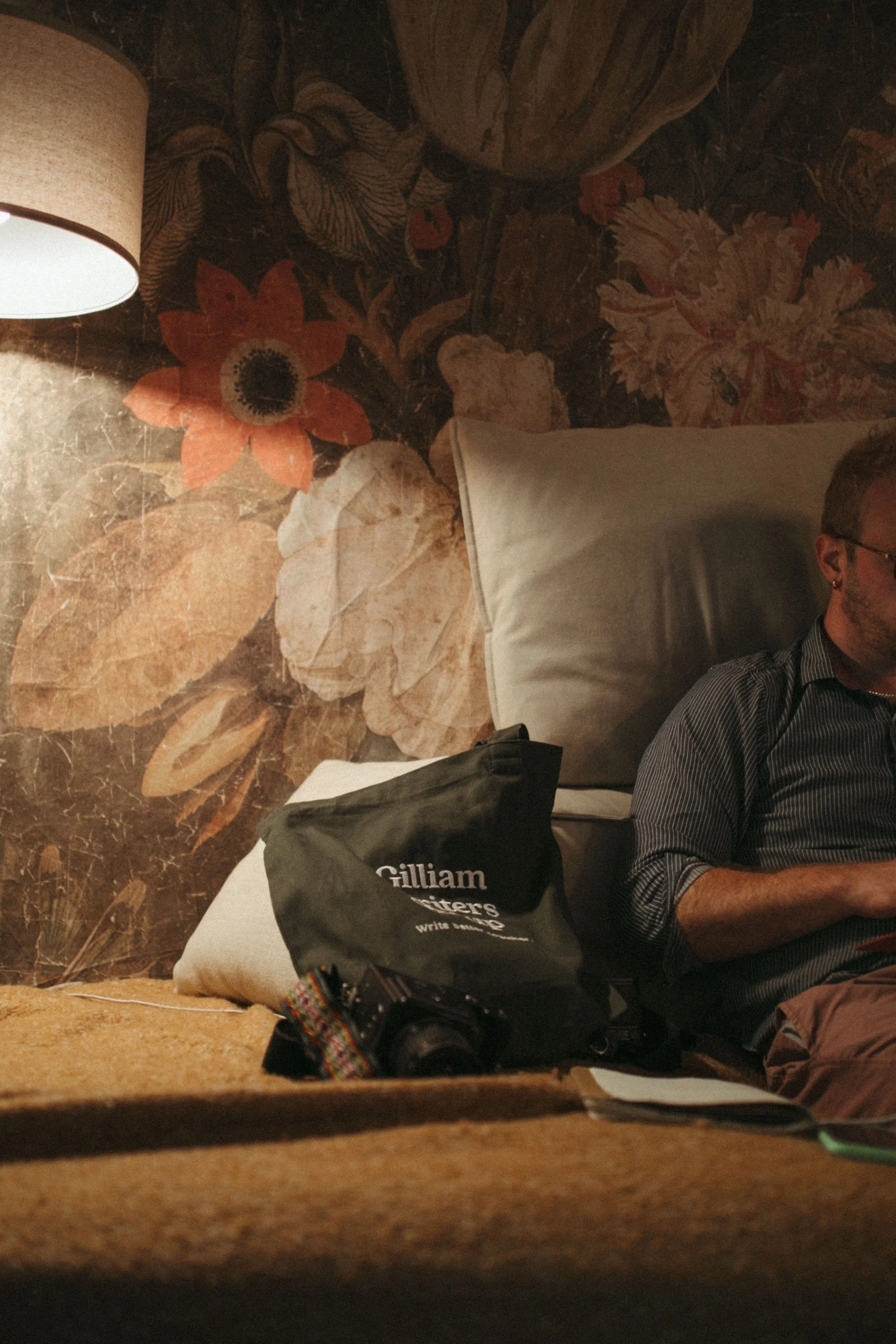 A Gilliam Writers Group tote bag resting on a couch beside a writer.