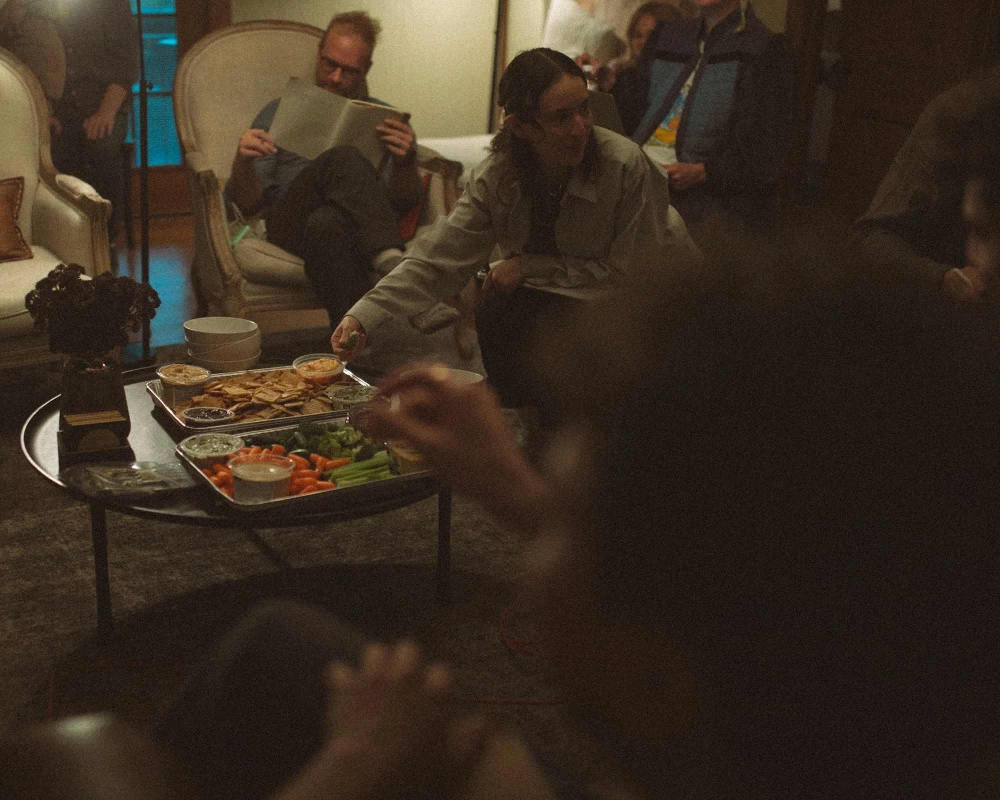 A GWG retreat attendee grabs a snack while her colleagues read and relax nearby.