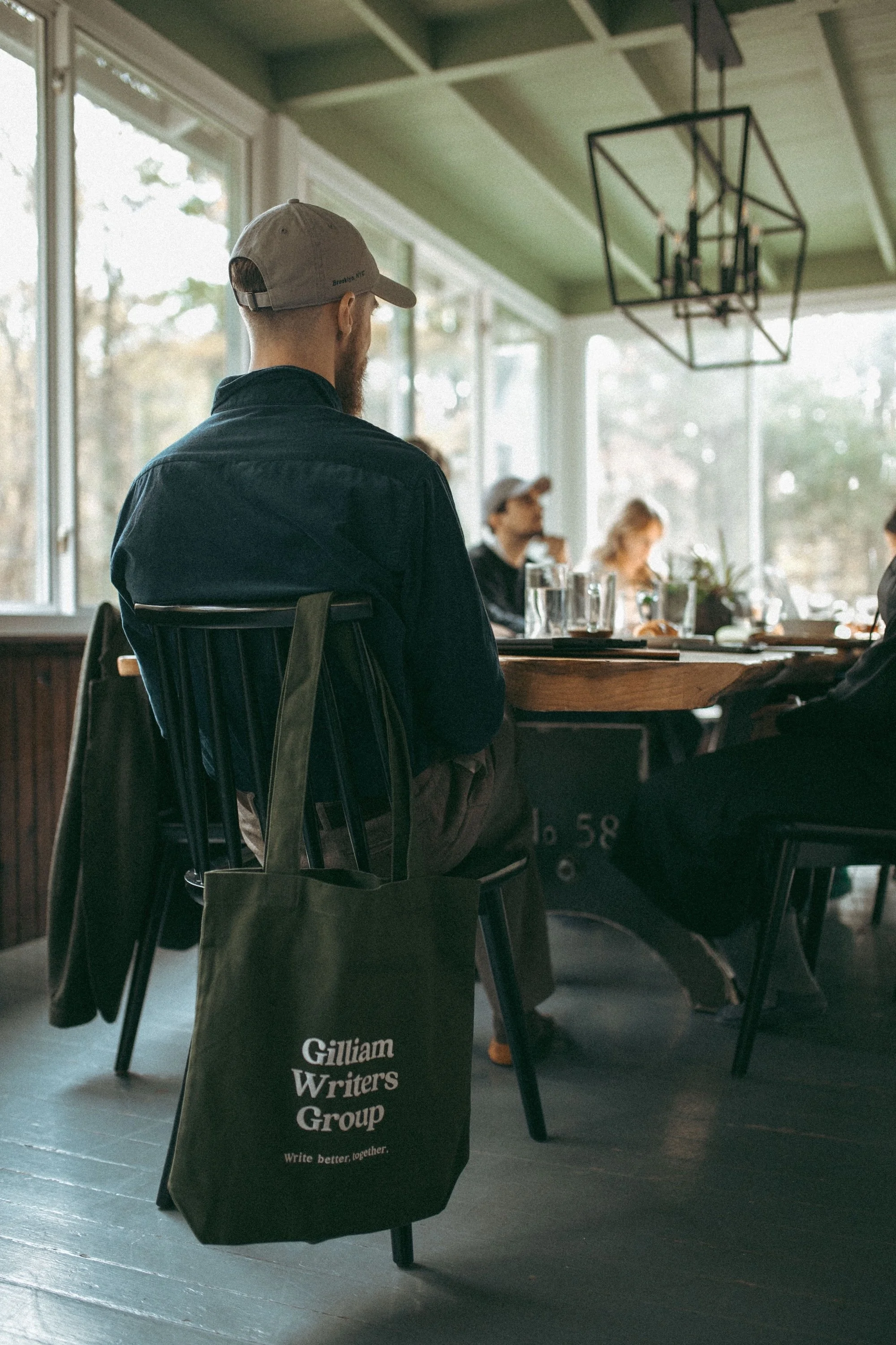 A faculty member with a Gilliam Writers Group tote seated at a workshop table.