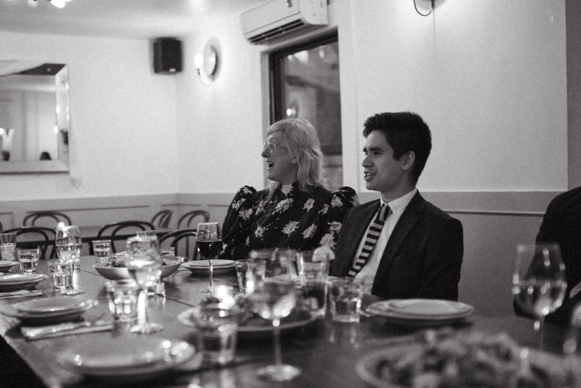 A Gilliam Writers Group faculty member and one guest literary agent laughing together over wine at dinner.