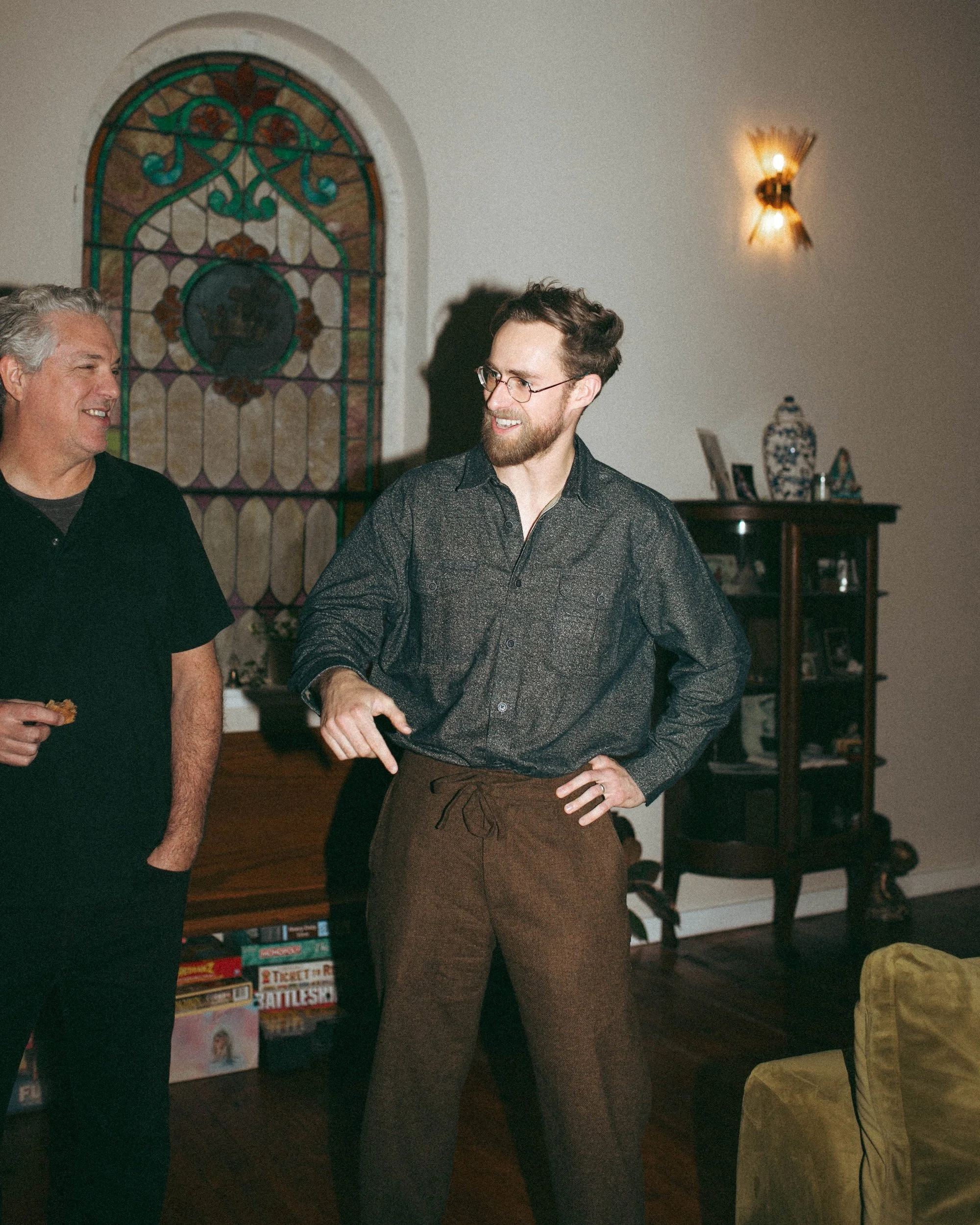 Brady Gilliam and one GWG faculty member talking beside a stained-glass window at a company event.