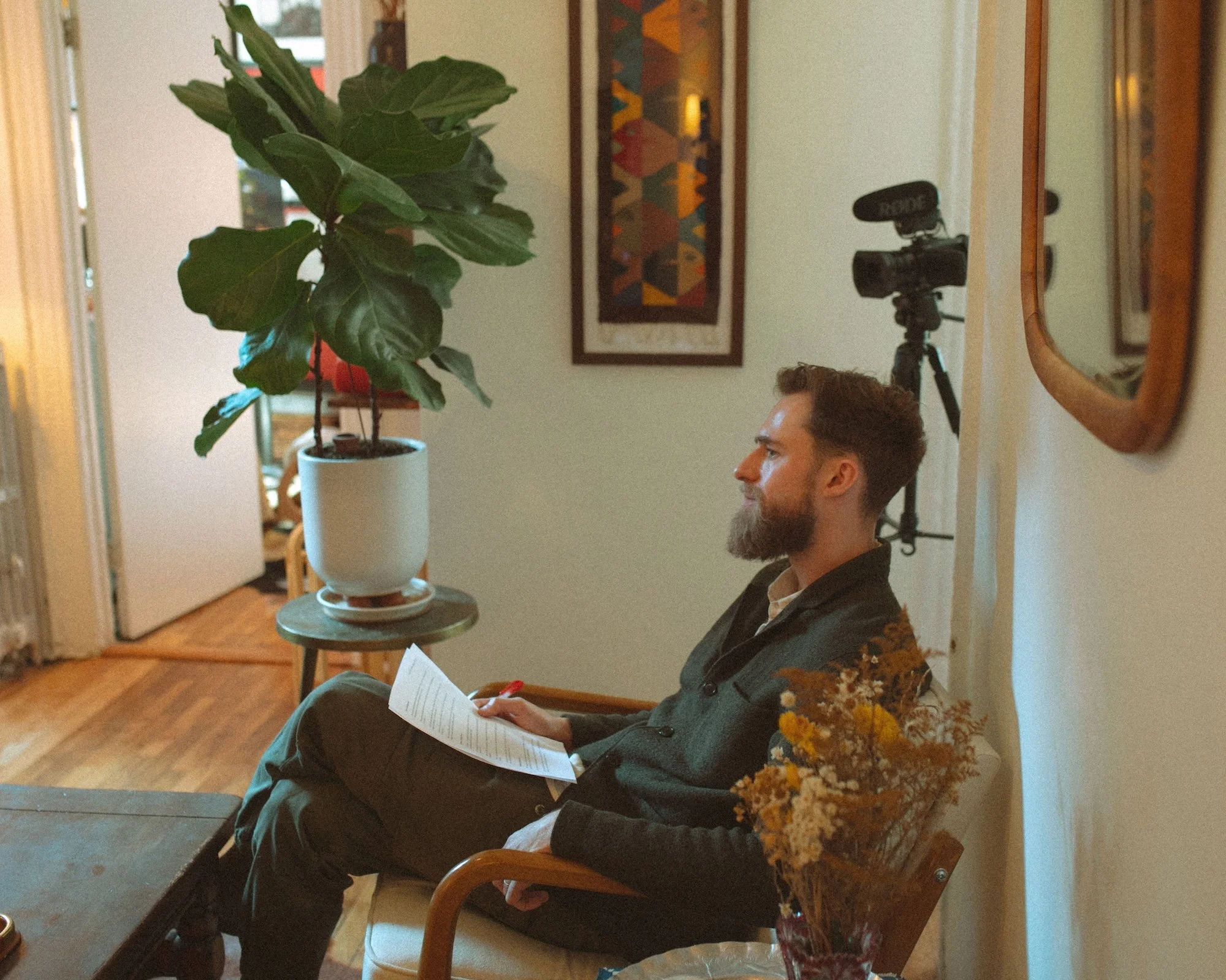 GWG founder Brady Gilliam reviews interview notes on camera beside a leafy potted plant.