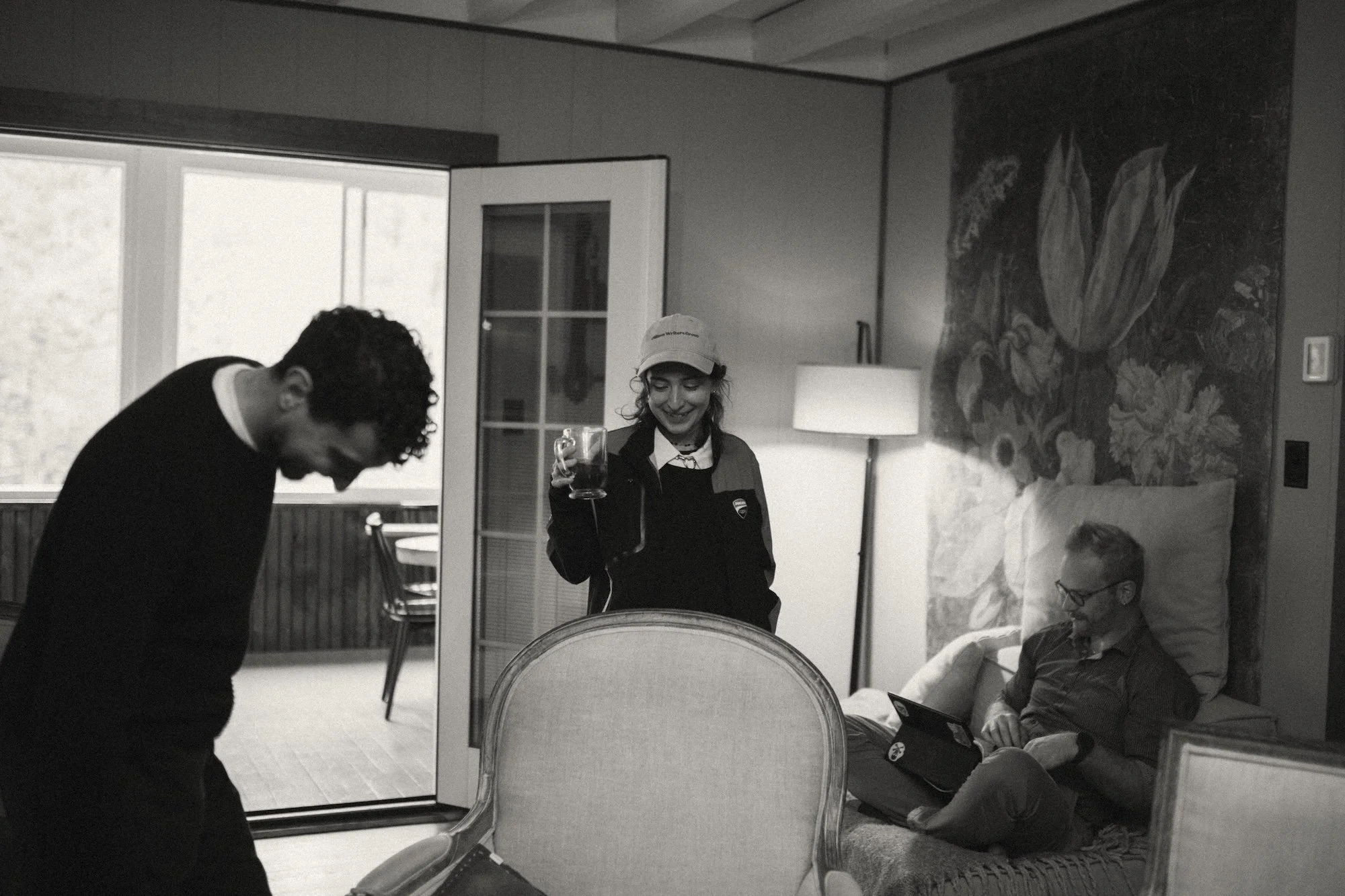 A retreat attendee in a Gilliam Writers Group cap sharing coffee with colleagues.