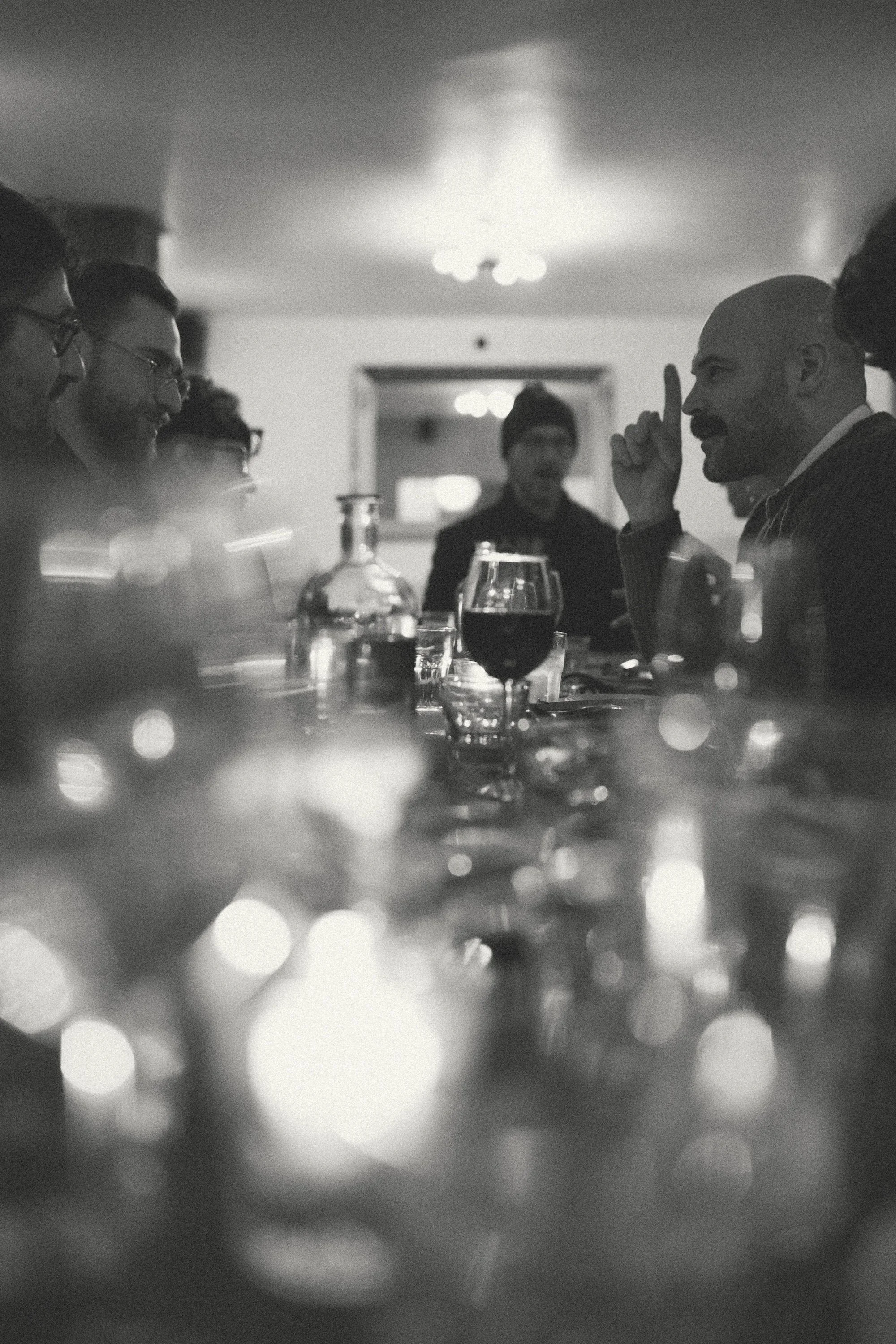 A GWG faculty member making a point across a candlelit dinner table.