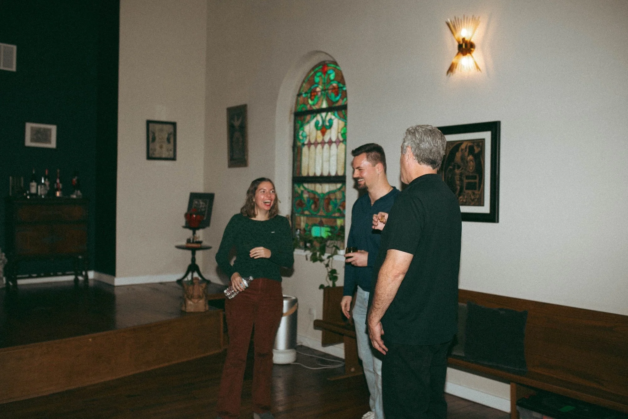 Gilliam Writers Group faculty laughing together in a converted-church event space.