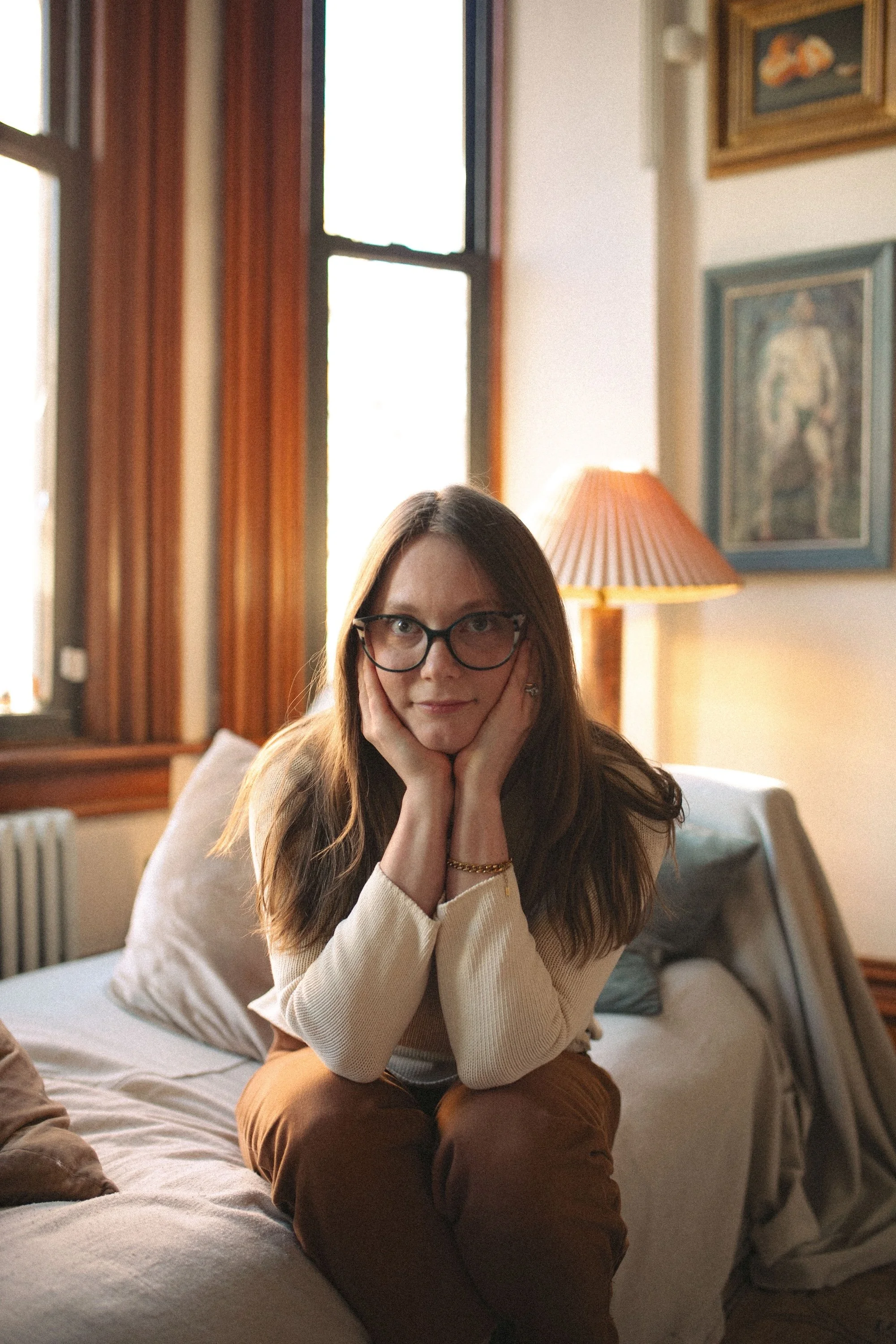 A relaxed writer's portrait in golden afternoon window light.