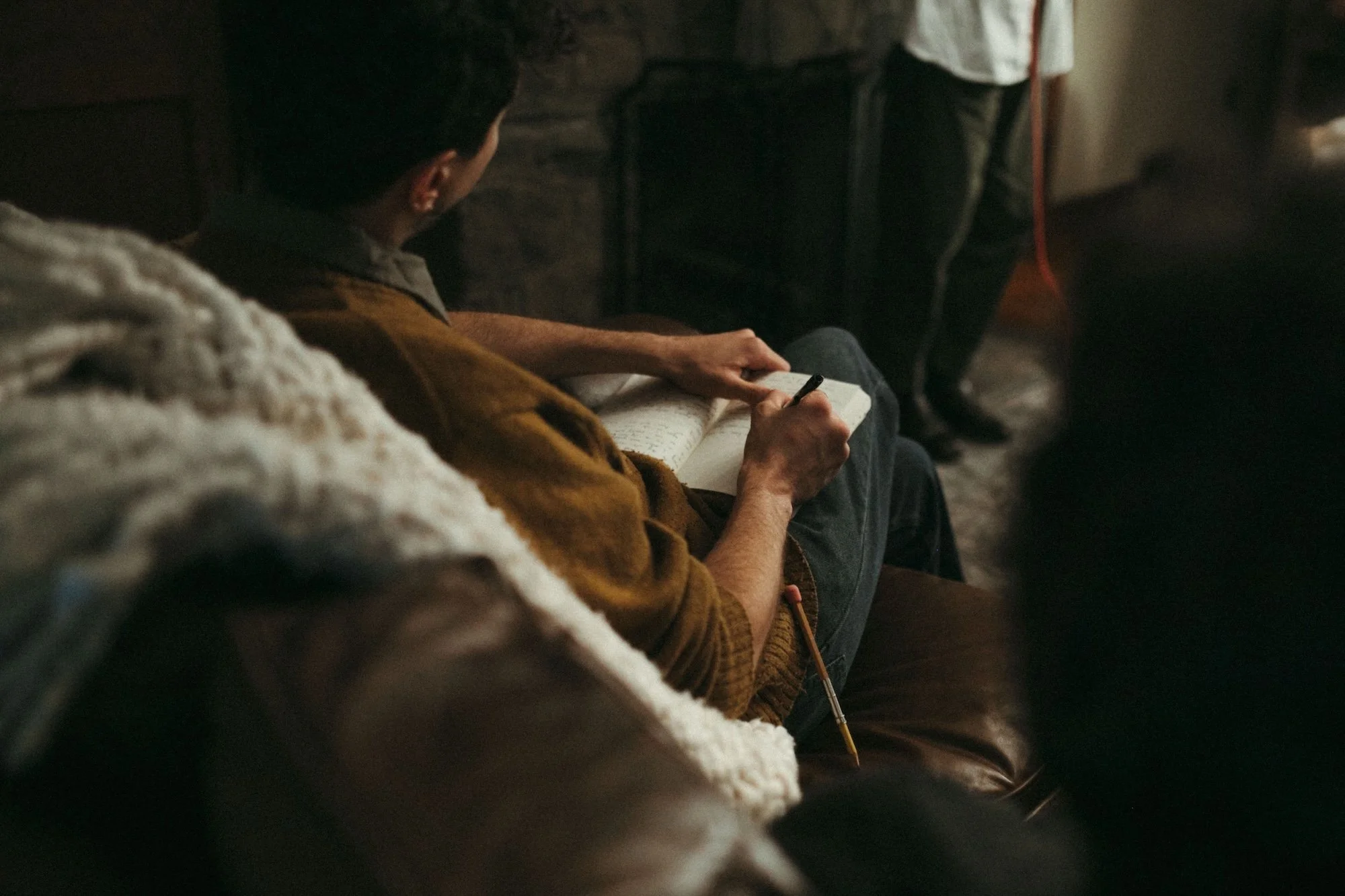 A writing coach drafting by hand in a notebook during the retreat.