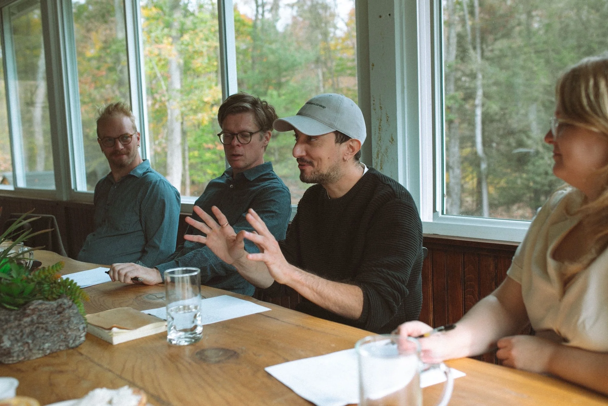 Gilliam Writers Group faculty in animated discussion at a sunlit table.