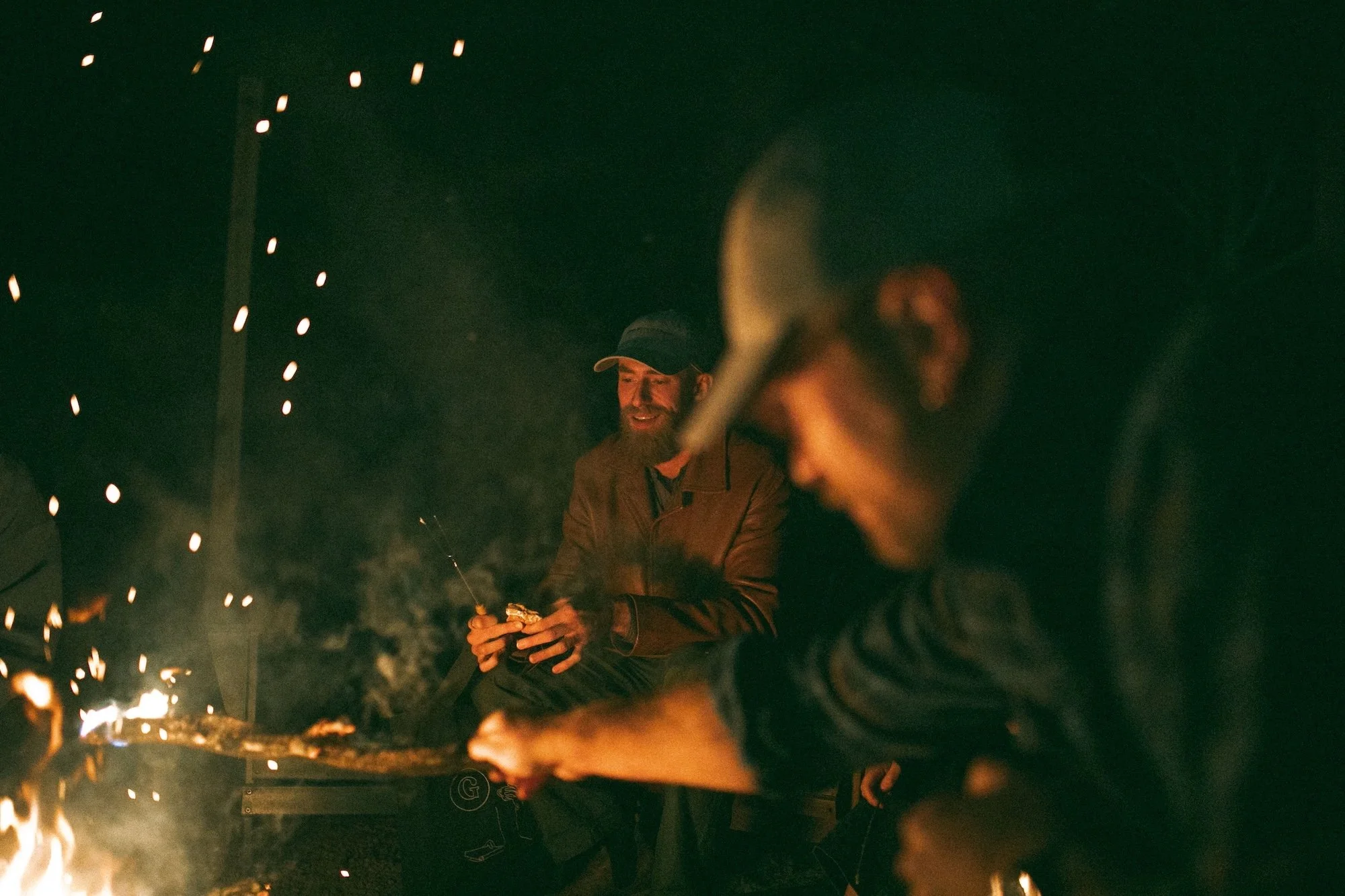 Gilliam Writers Group faculty gathered around a crackling bonfire at night.