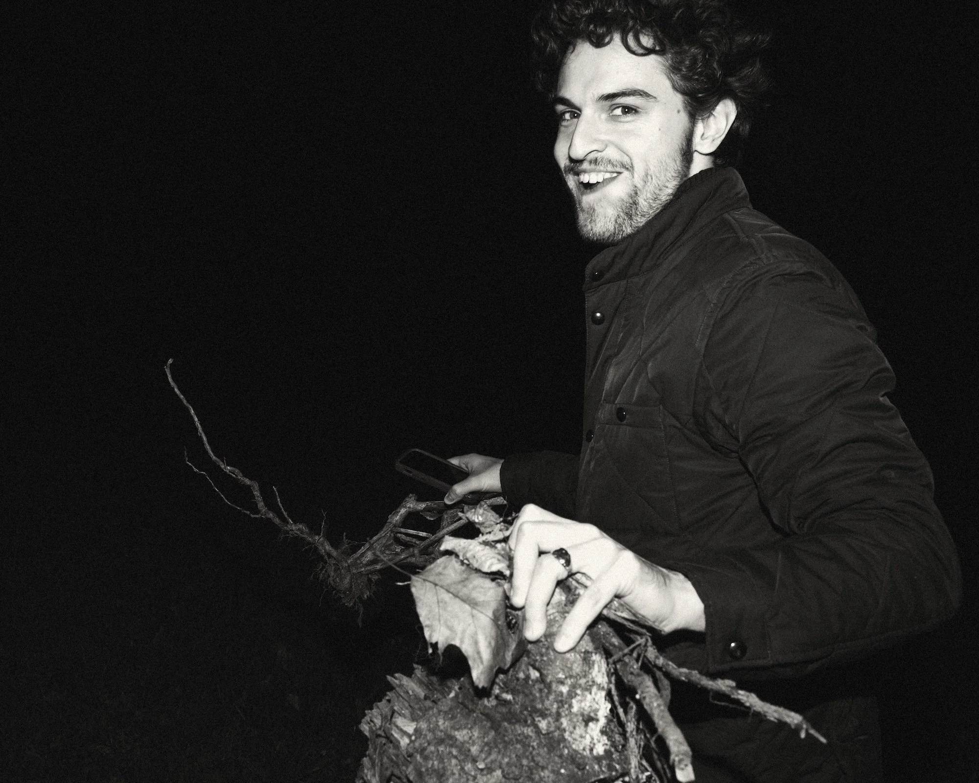 A writer smiling while gathering kindling for the evening fire.