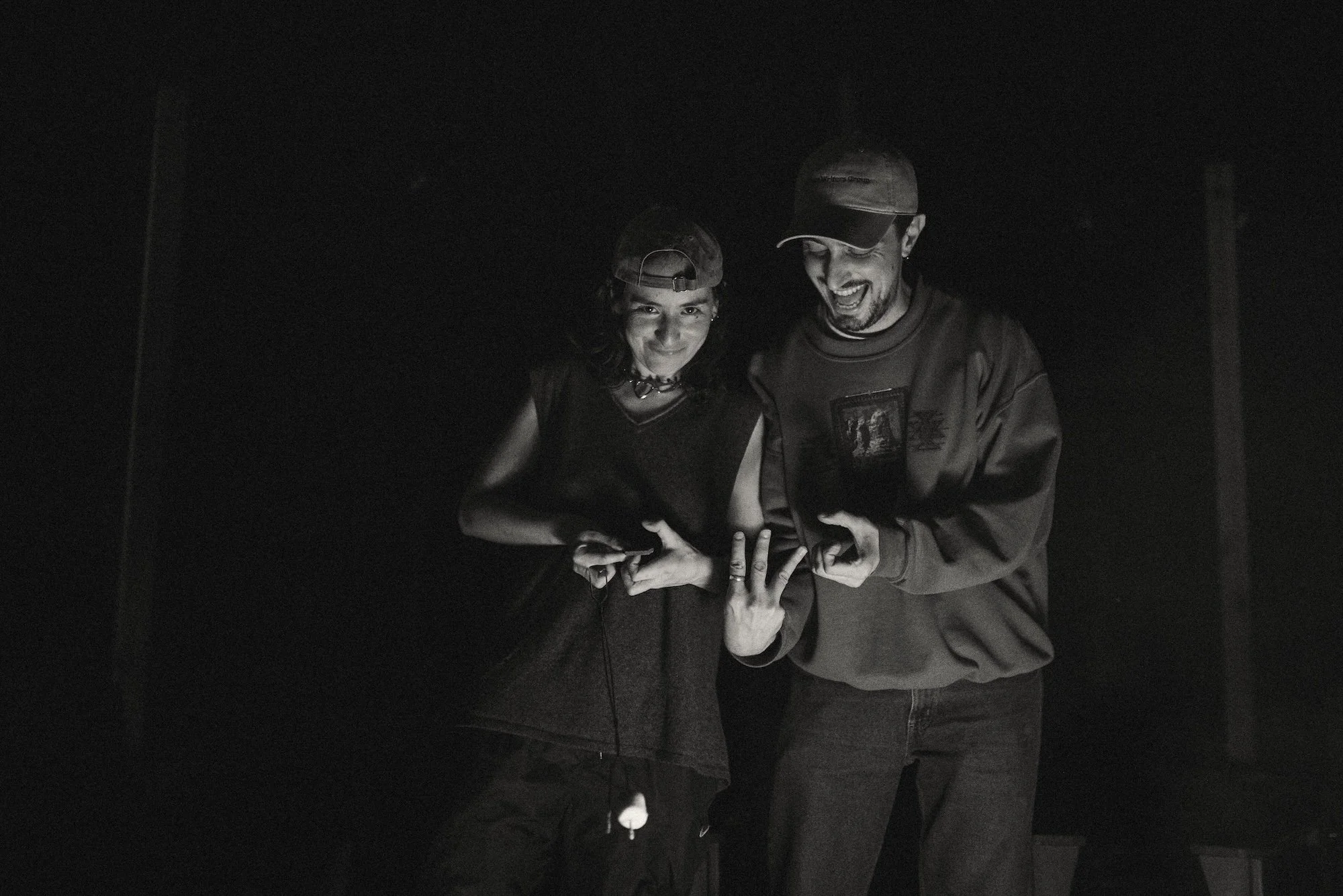 Two writers grinning by the firelight.