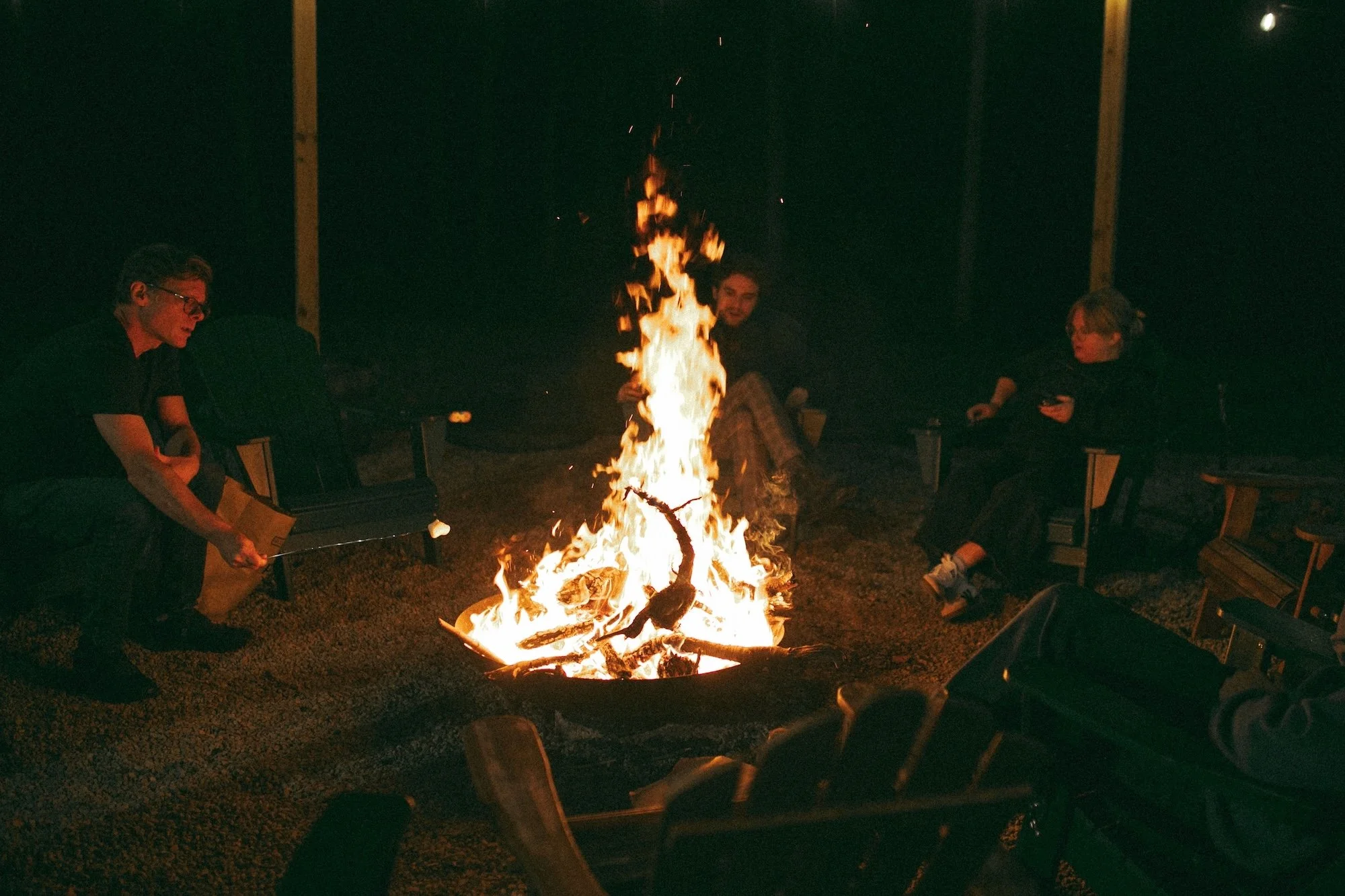 Gilliam Writers Group colleagues relaxing around a bonfire under the trees.