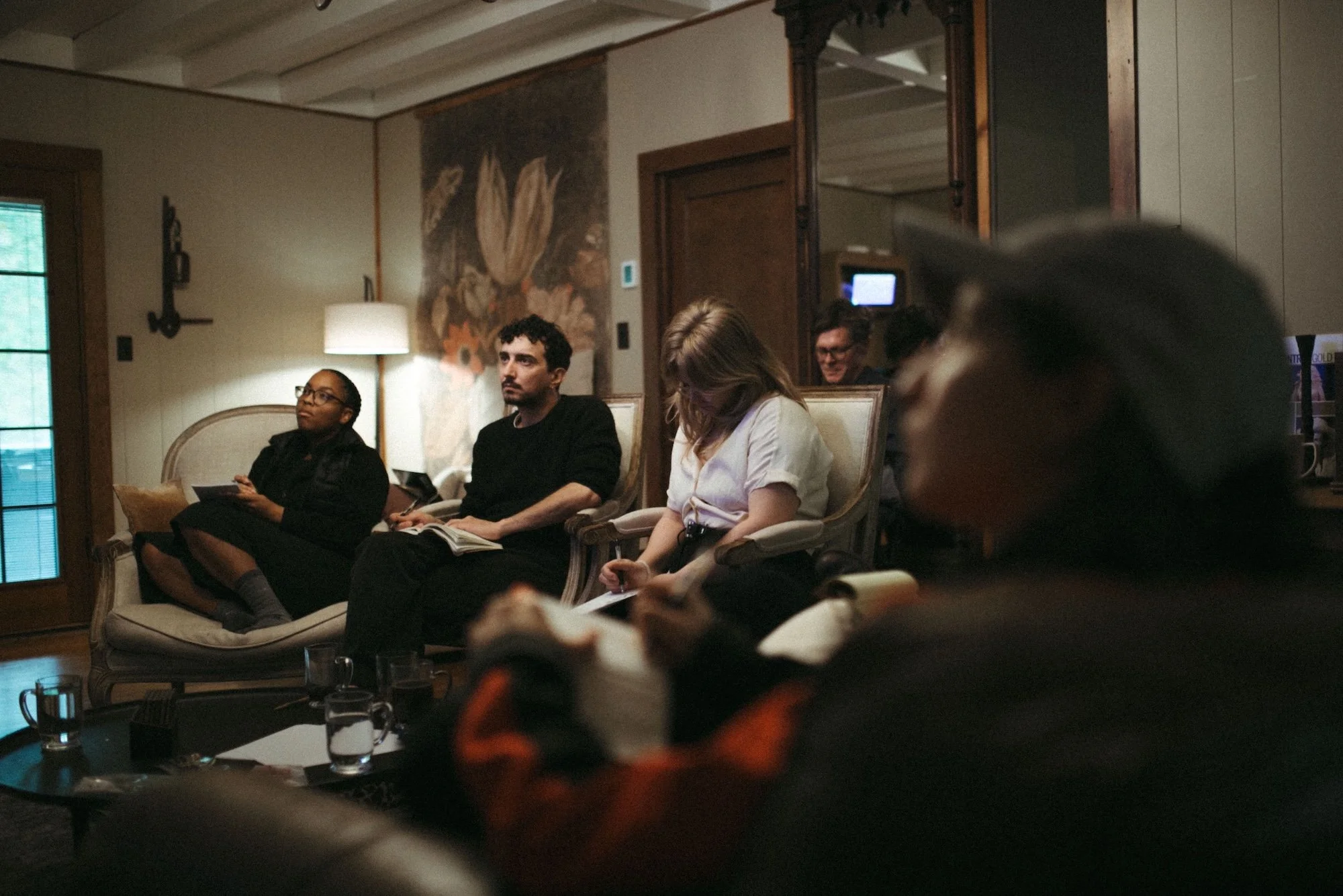 Writers taking notes during a workshop session in the living room of the GWG retreat house.
