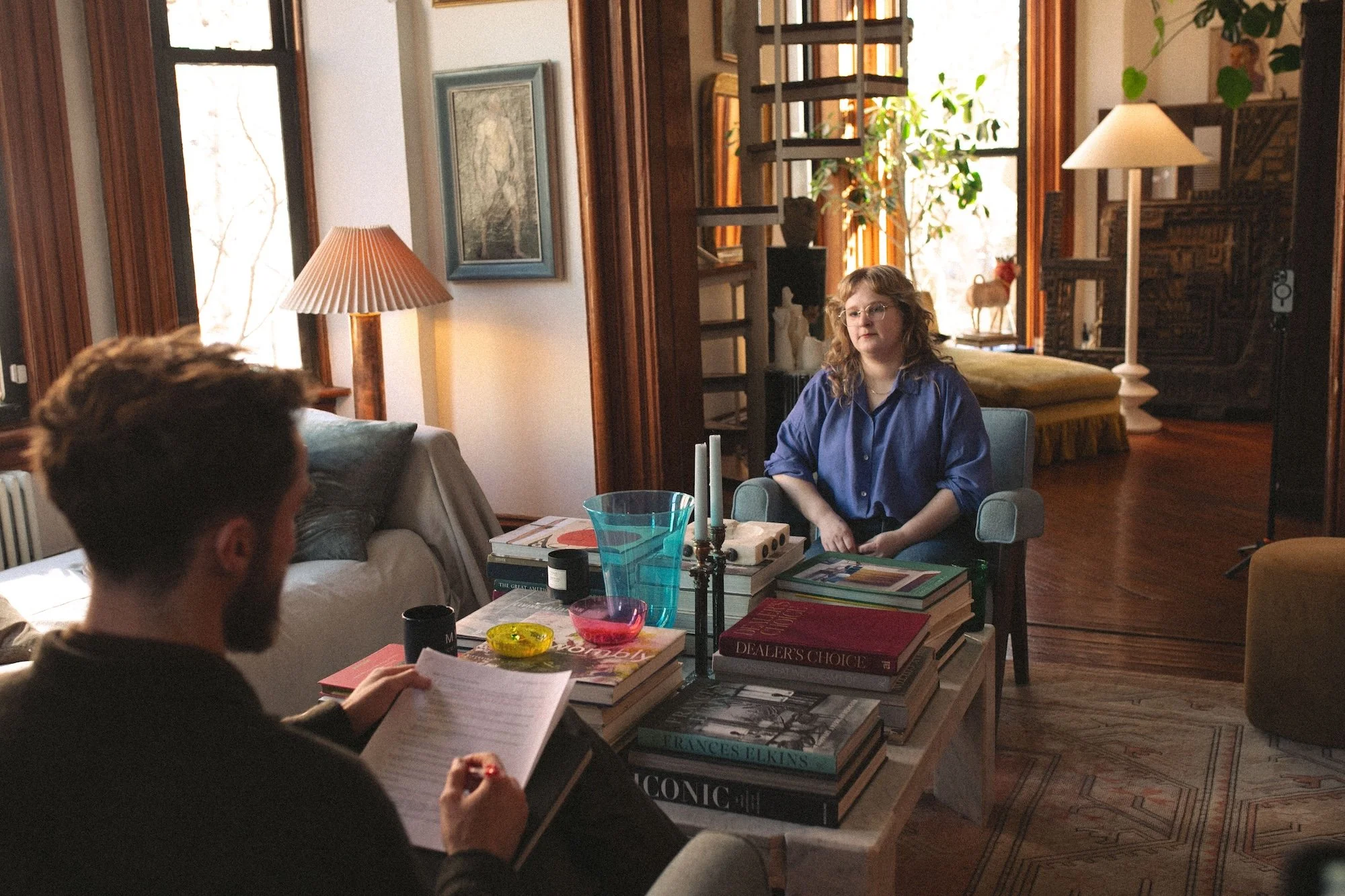 A GWG faculty member listening during a filmed living-room interview.