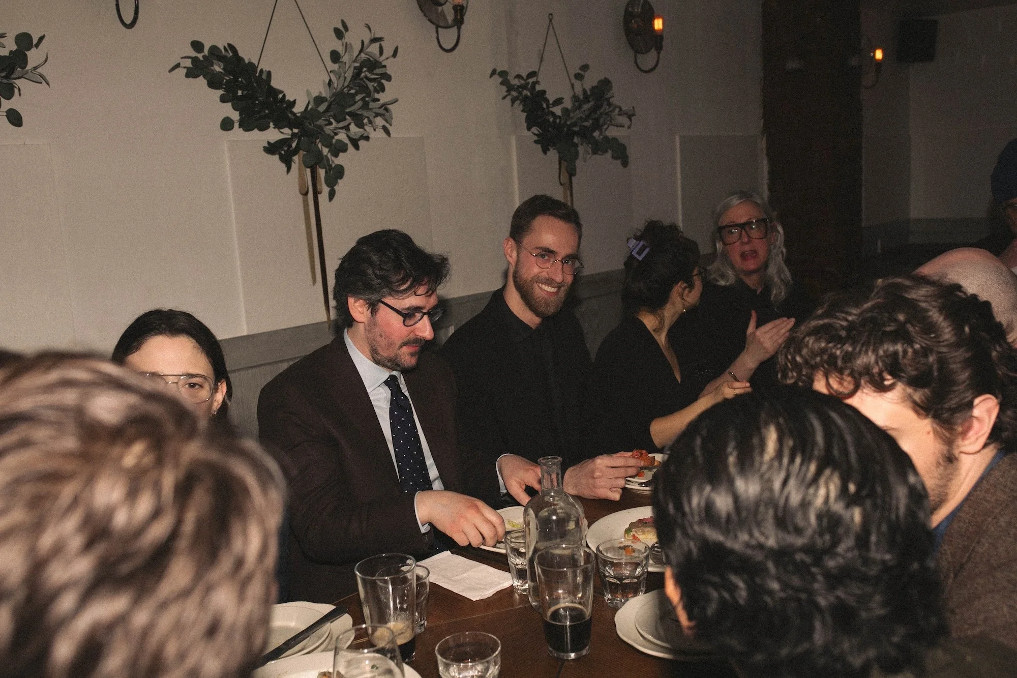 Gilliam faculty and visiting writers sharing food and conversation along a long community table.