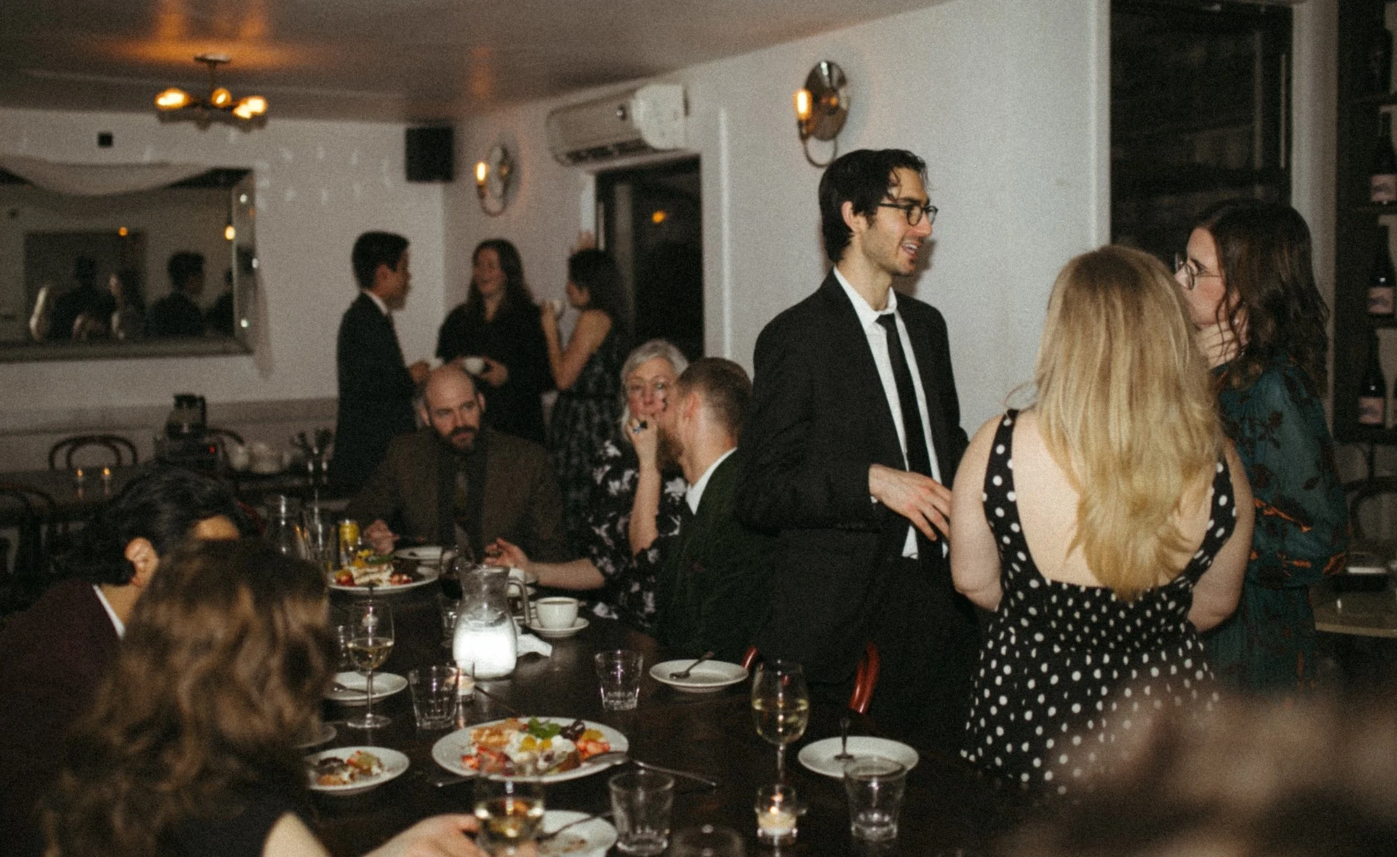 A lively Gilliam Writers Group community dinner with faculty mingling around the table.