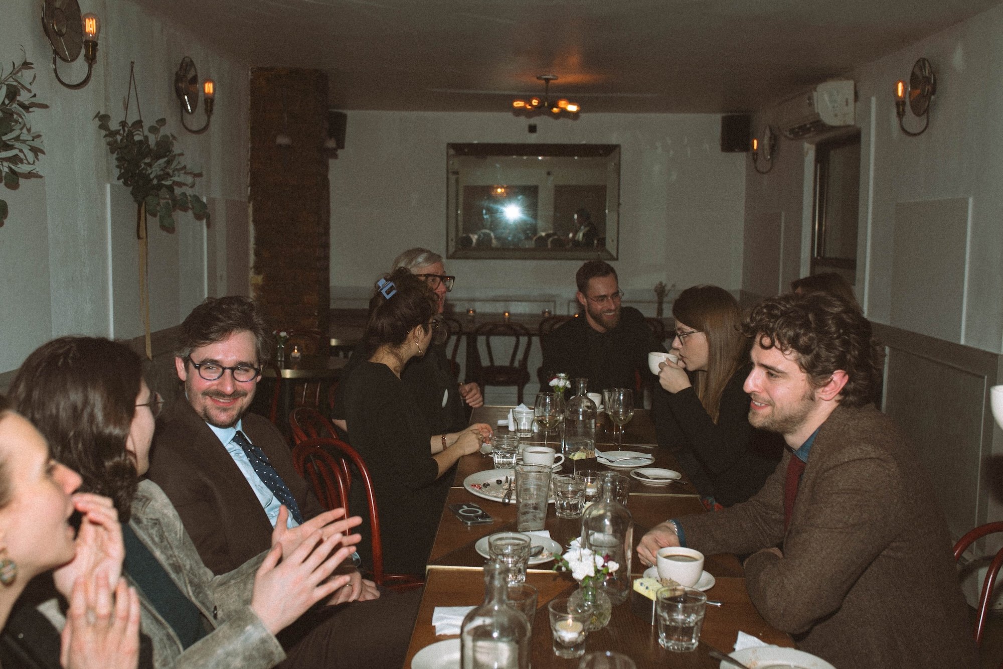 Gilliam Writers Group faculty sharing coffee and conversation along a long table.