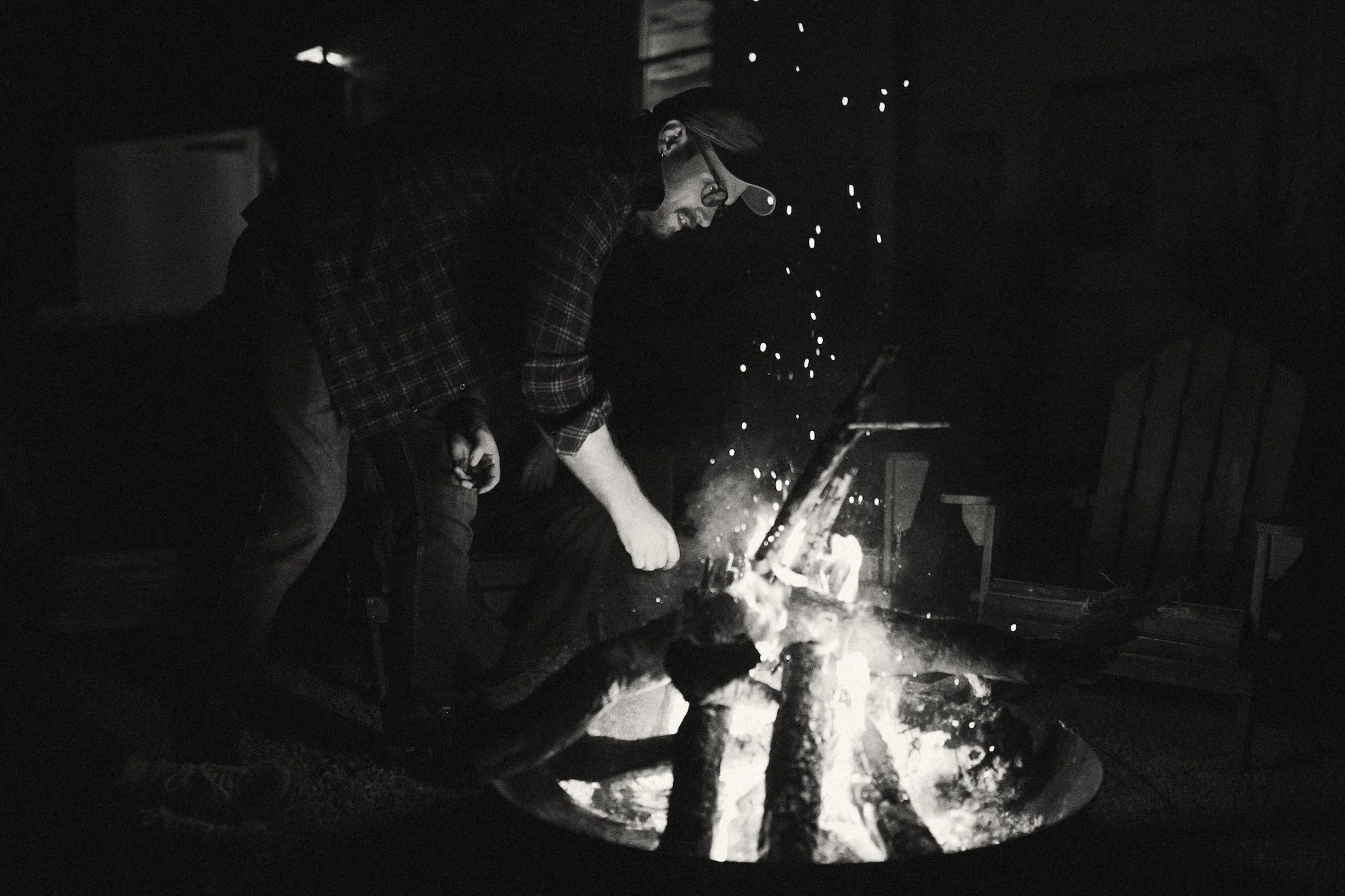 A writer tending the fire as sparks rise into the night.