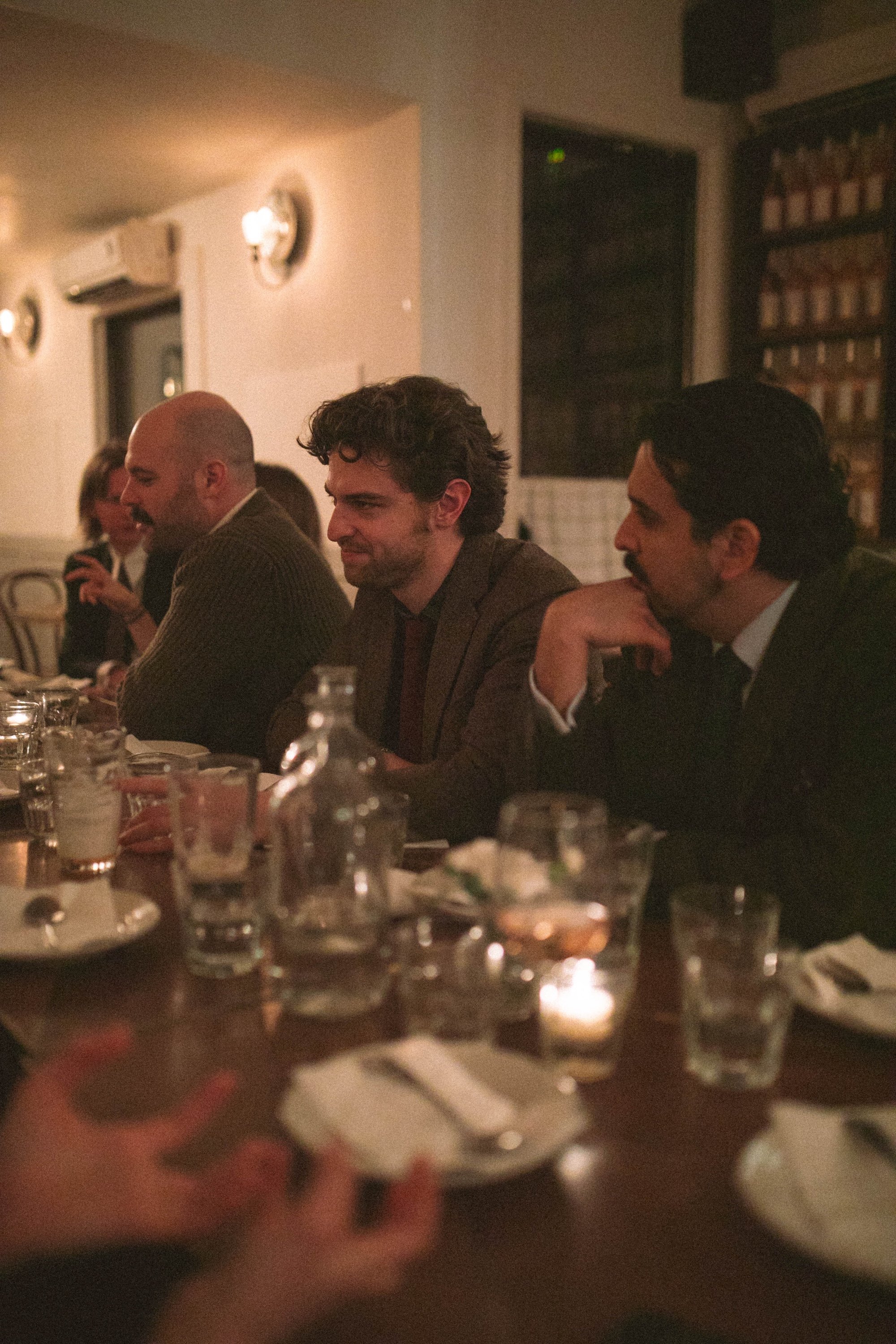 Gilliam Writers Group faculty seated in a row along a candlelit table.