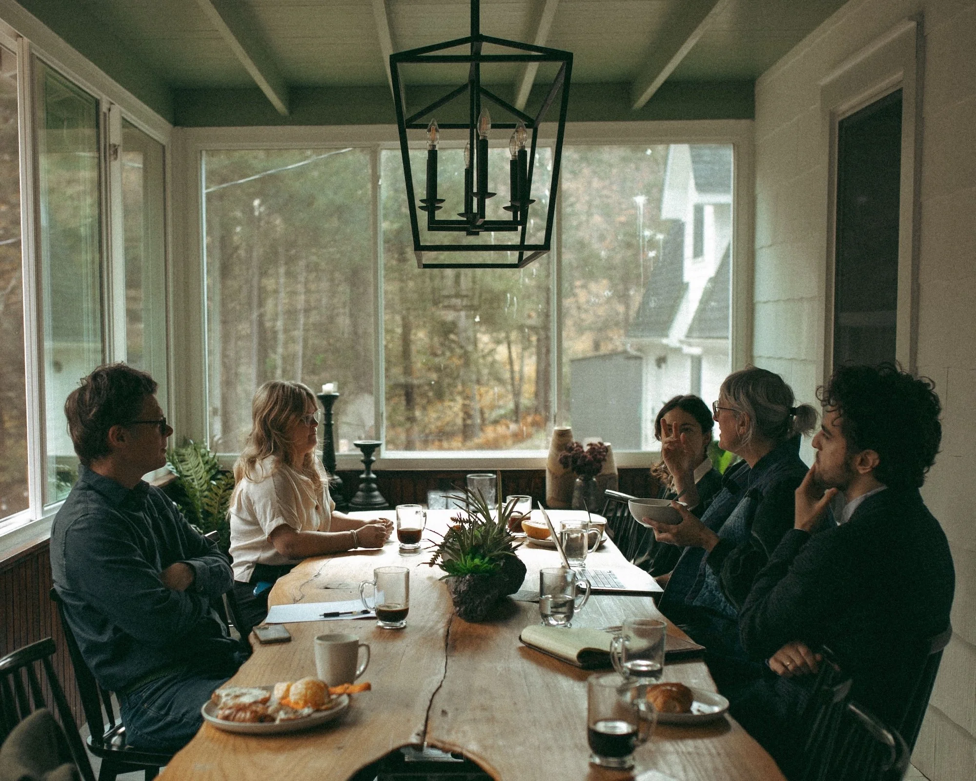 Gilliam Writers Group faculty in discussion around a sunlit table.