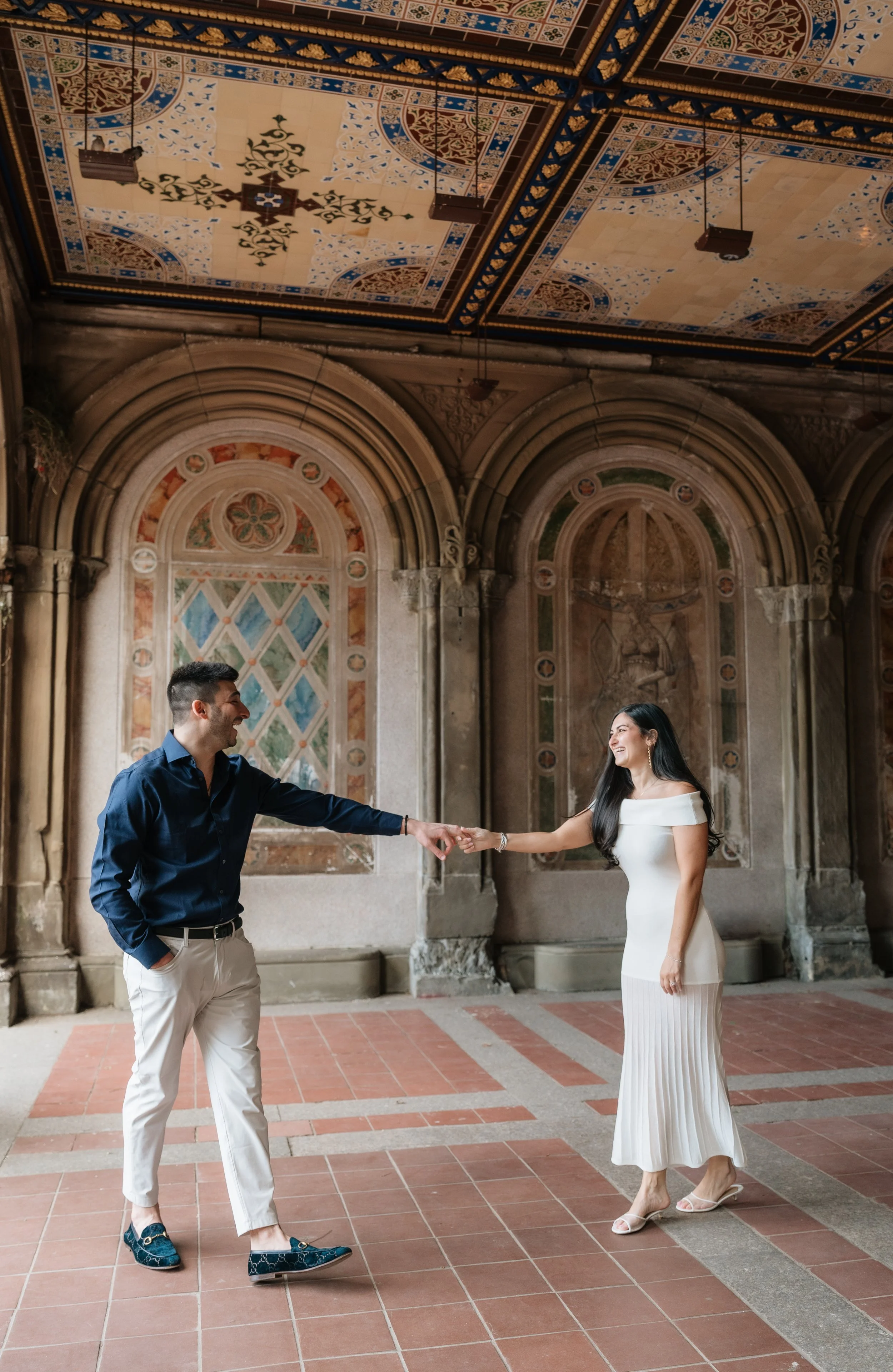 Couple embracing on the iconic Bethesda Terrace staircase during a Central Park engagement session in New York City.