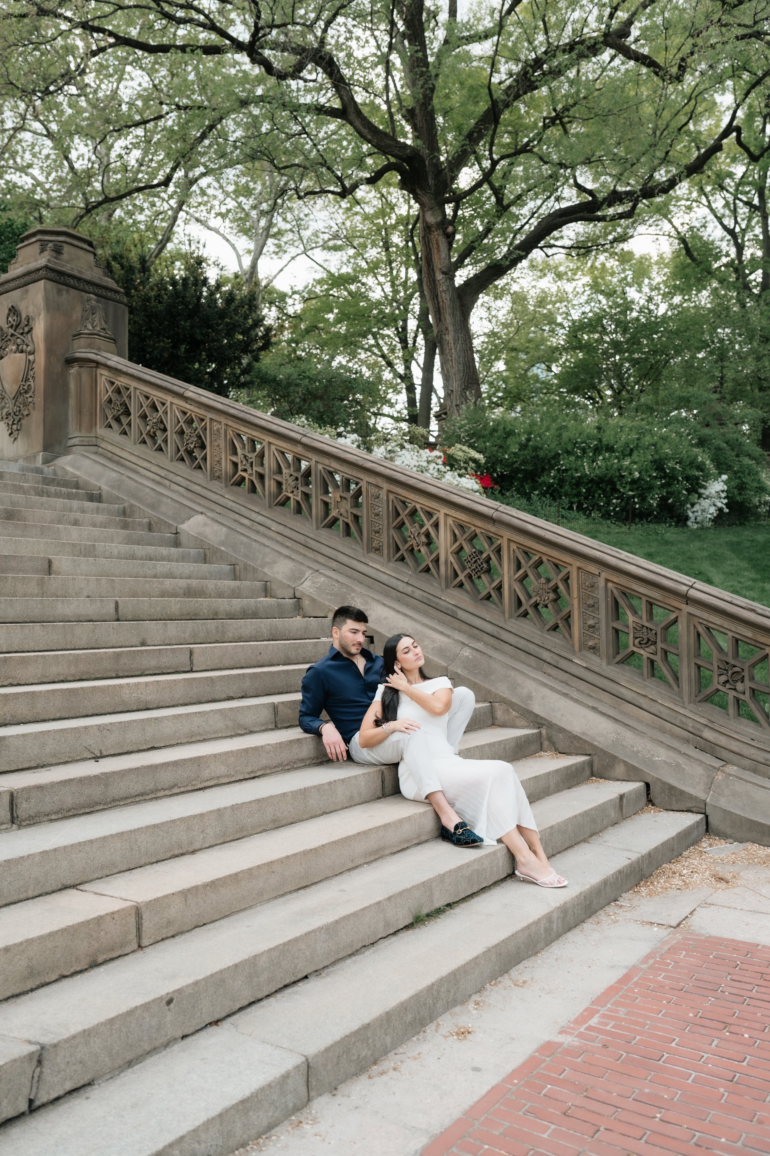 Couple embracing on the iconic Bethesda Terrace staircase during a Central Park engagement session in New York City.
