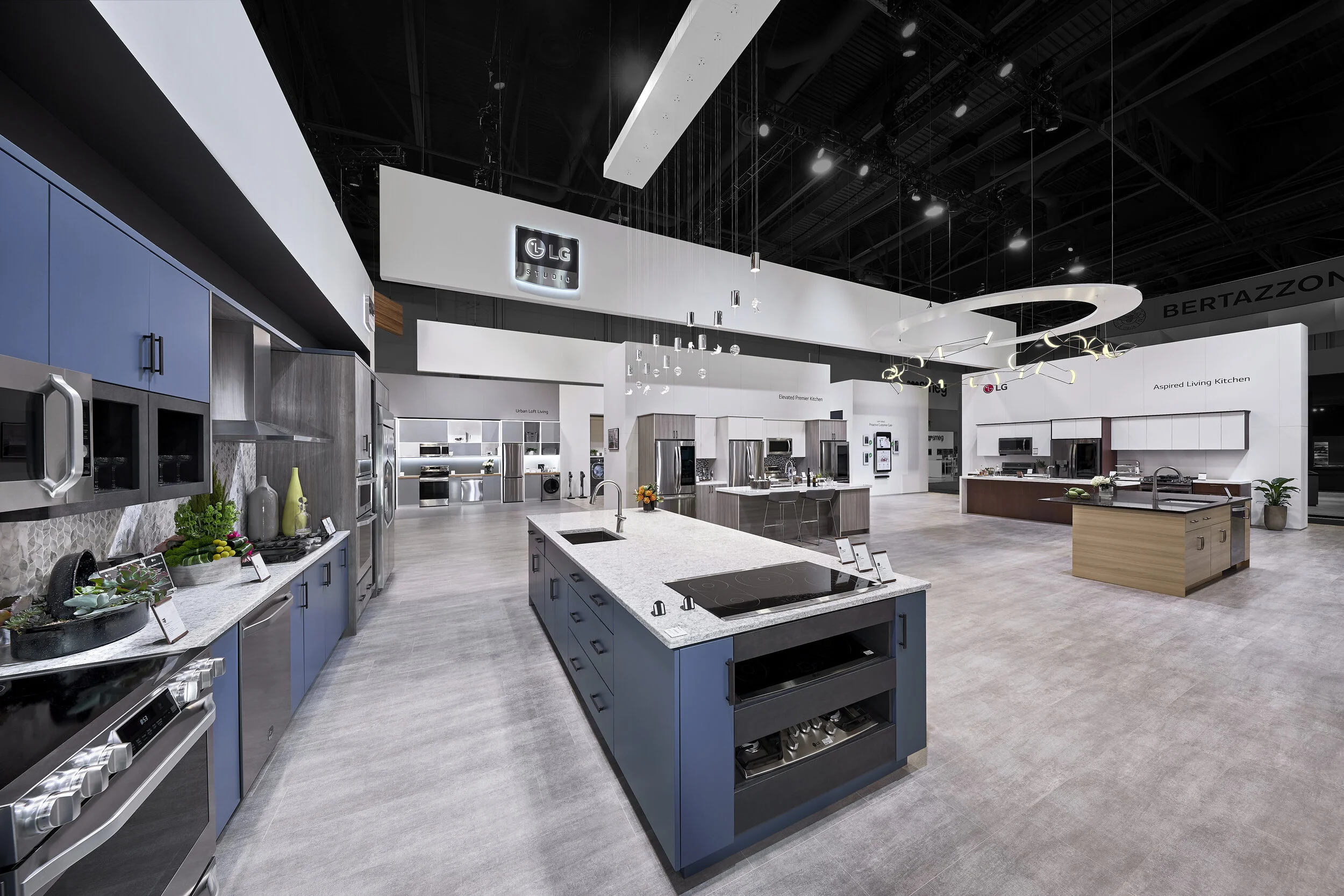 LG Signature tradeshow booth at KBIS conference in Las Vegas showcasing smart stainless steel appliances and blue kitchen cabinets.
