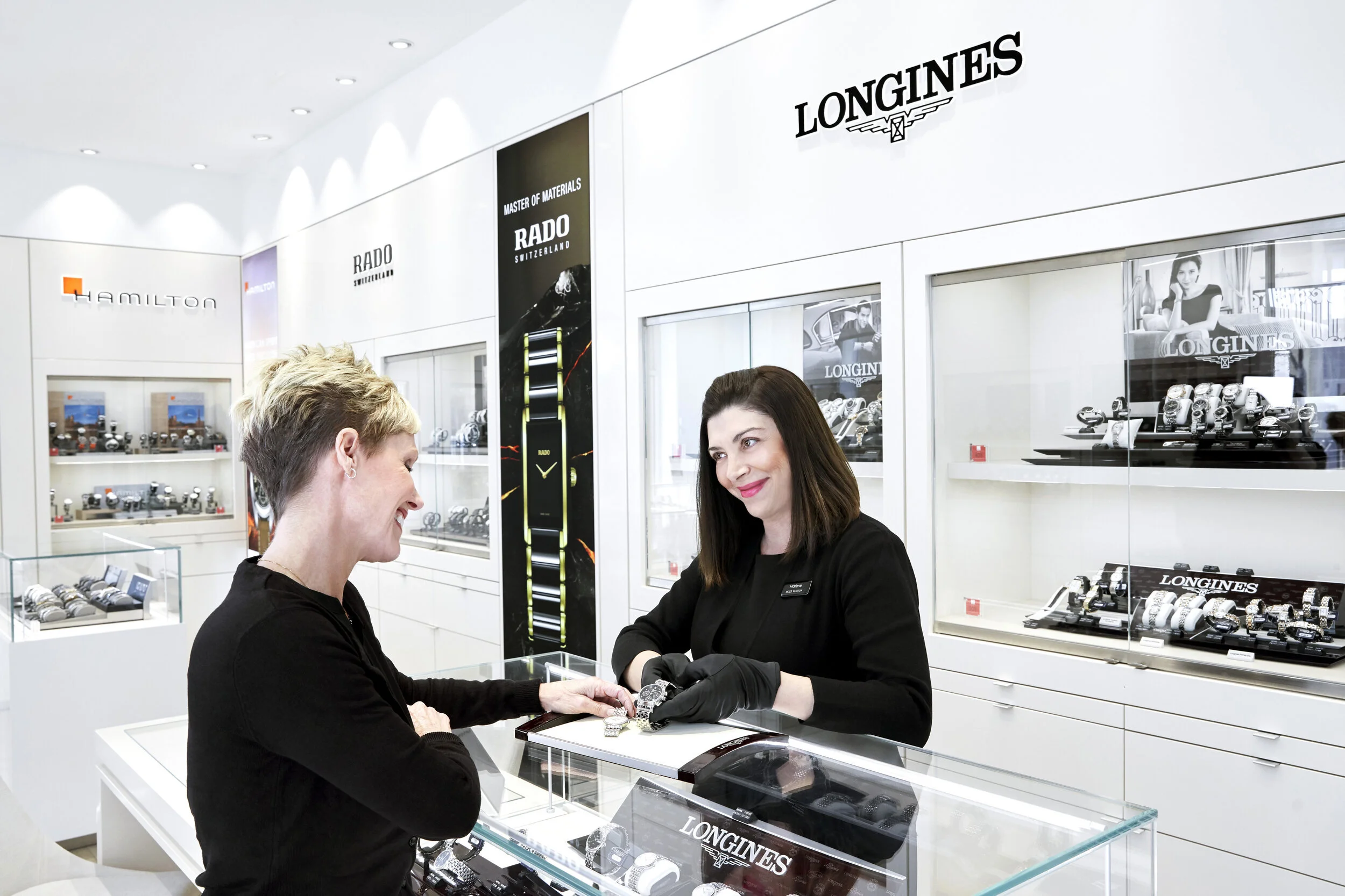 Hour Passion boutique associate is helping a customer with their luxury watch purchase.