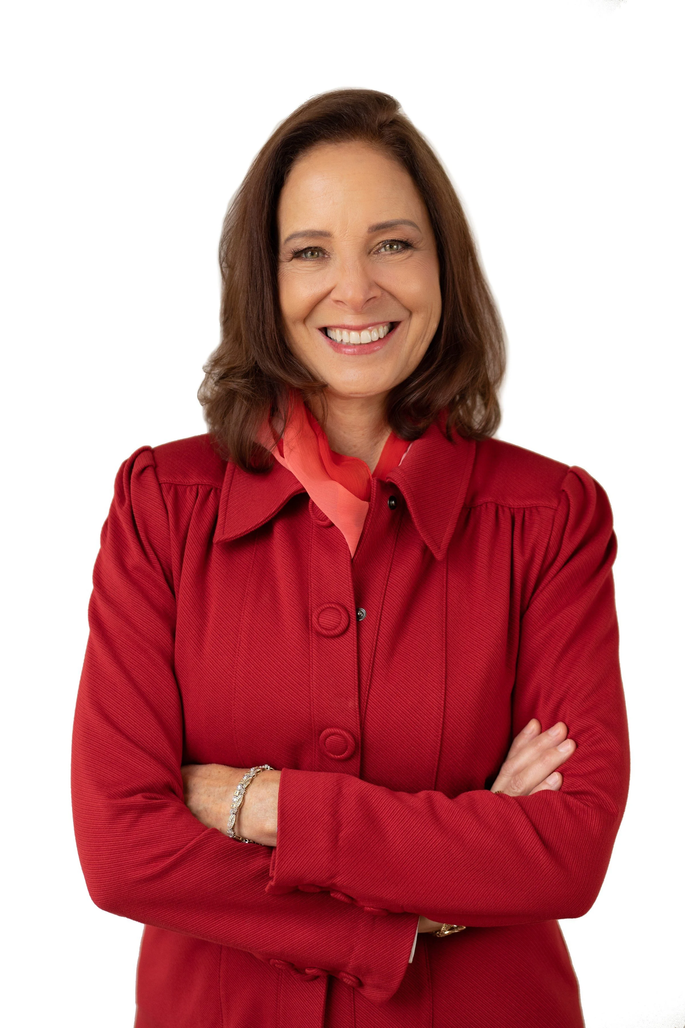 Smiling woman with brown hair wearing a red blazer and crossing her arms, posing against a white background.