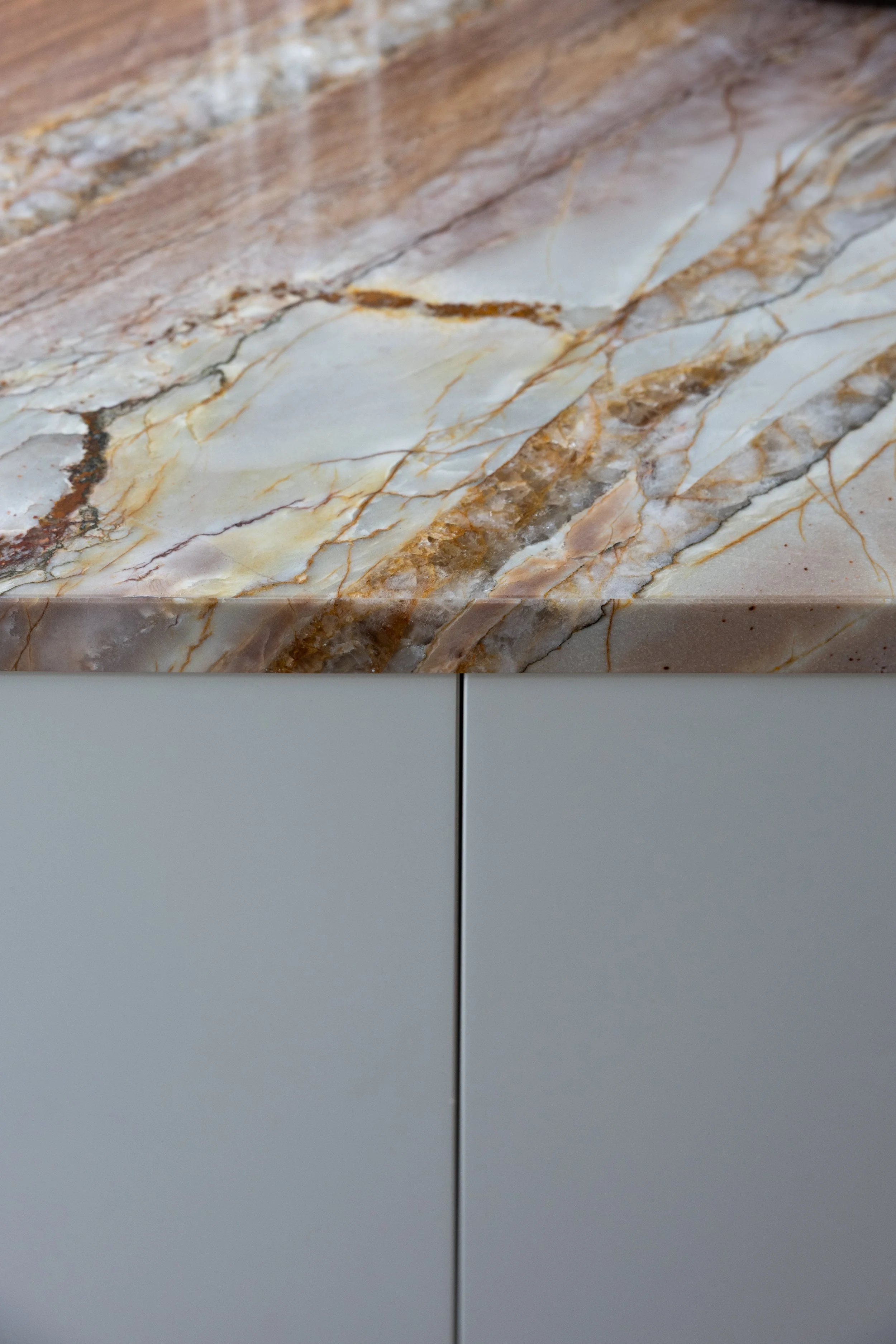 Studio GD – quartzite countertop detail: Modern kitchen with push-to-open cabinetry.