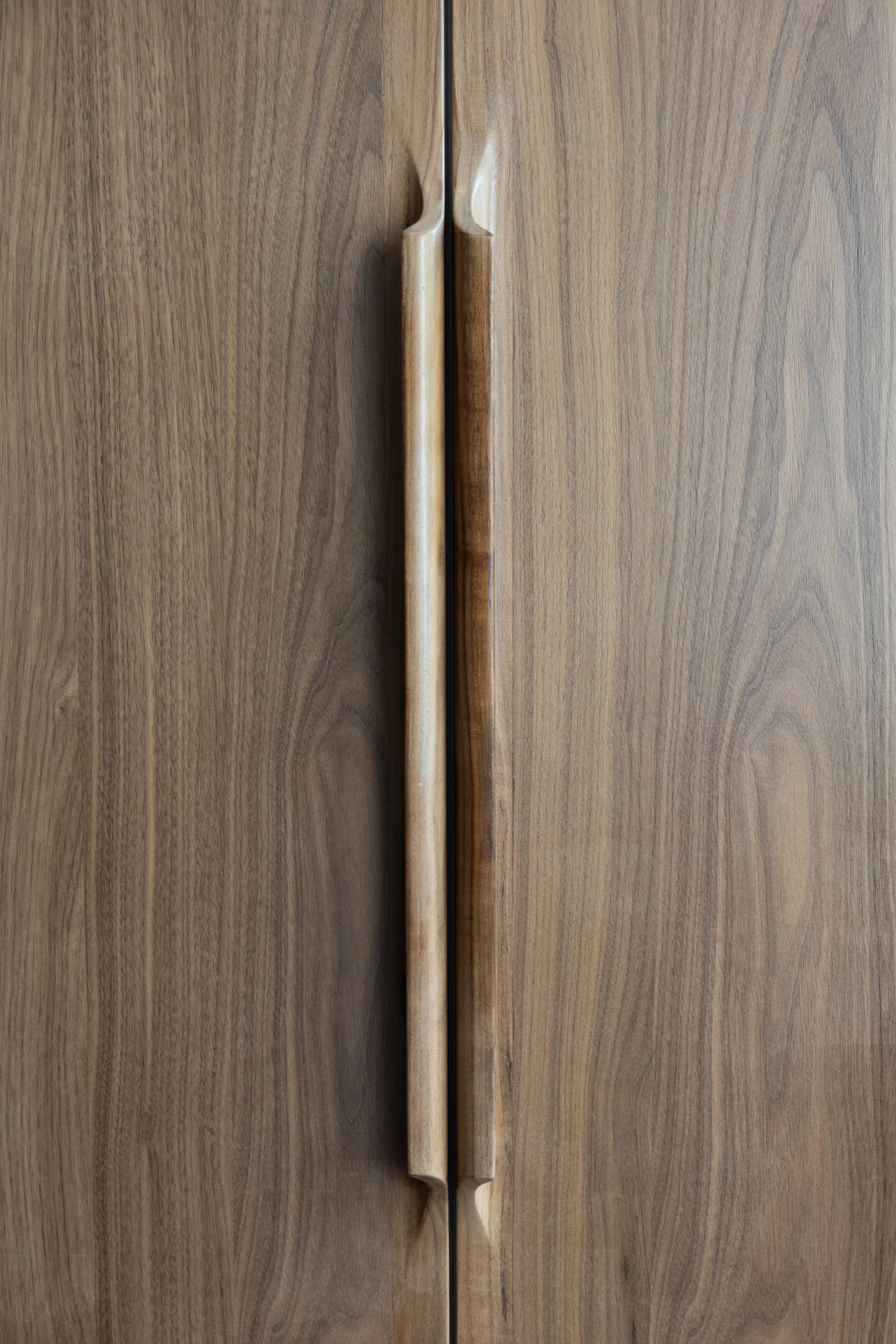Studio GD kitchen – walnut details: Custom fridge/freezer doors, hand-carved wooden handles, material integrity.