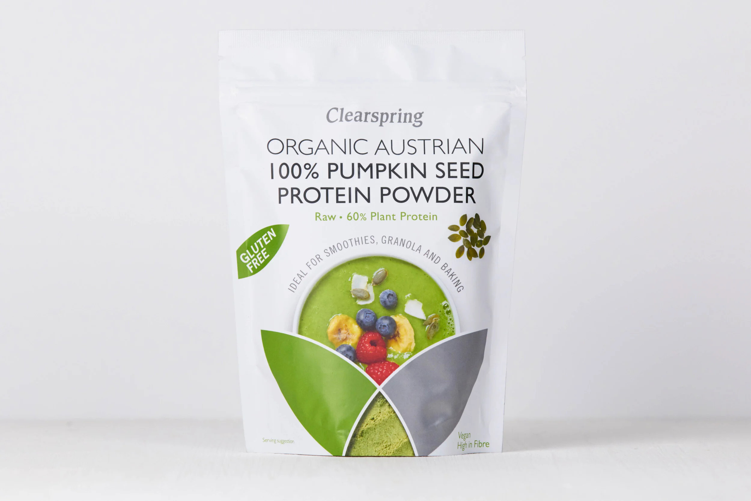 Packaging of ClearSpring Organic Austrian pumpkin seed protein powder, labeled gluten-free, vegan, with 60% plant protein, showing a bowl of green smoothie with berries and banana slices.