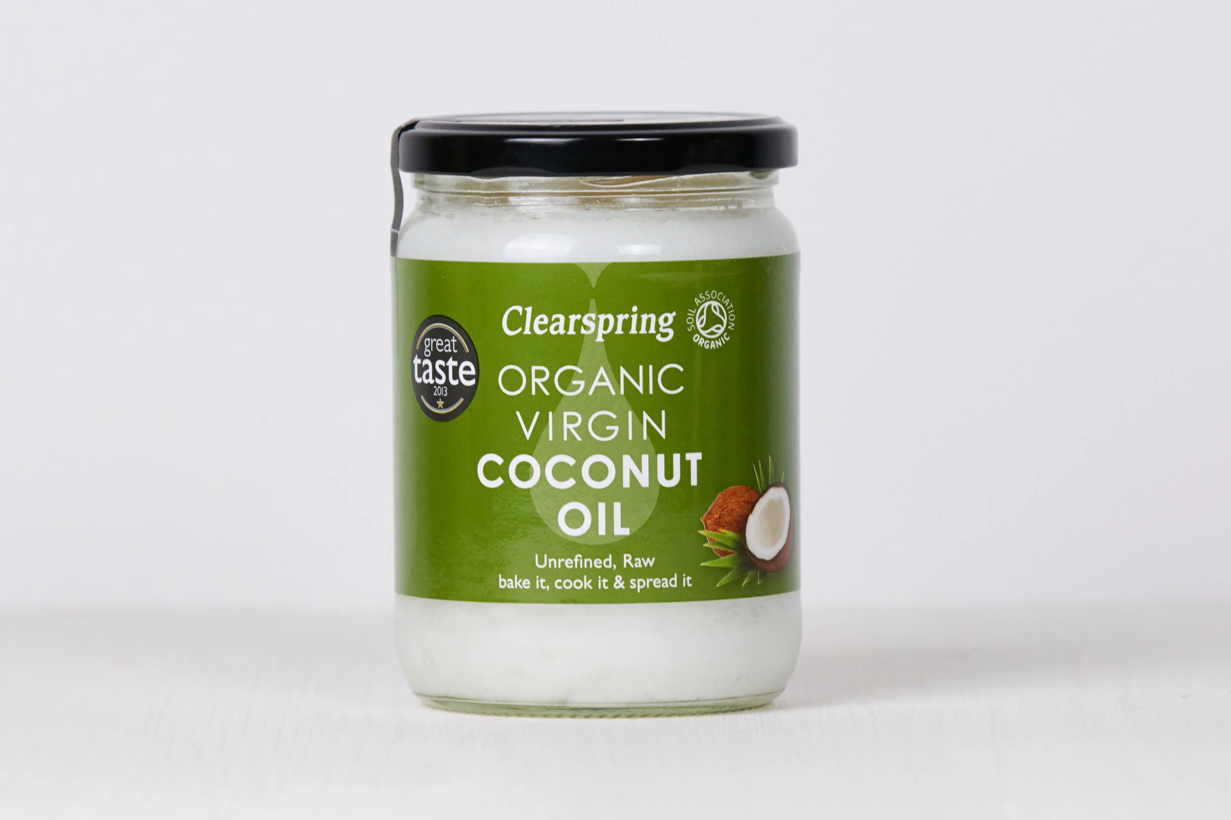 Jar of Clearspring organic virgin coconut oil with a green label showing a coconut image and the text 'Unrefined, Raw, bake it, cook it & spread it'.