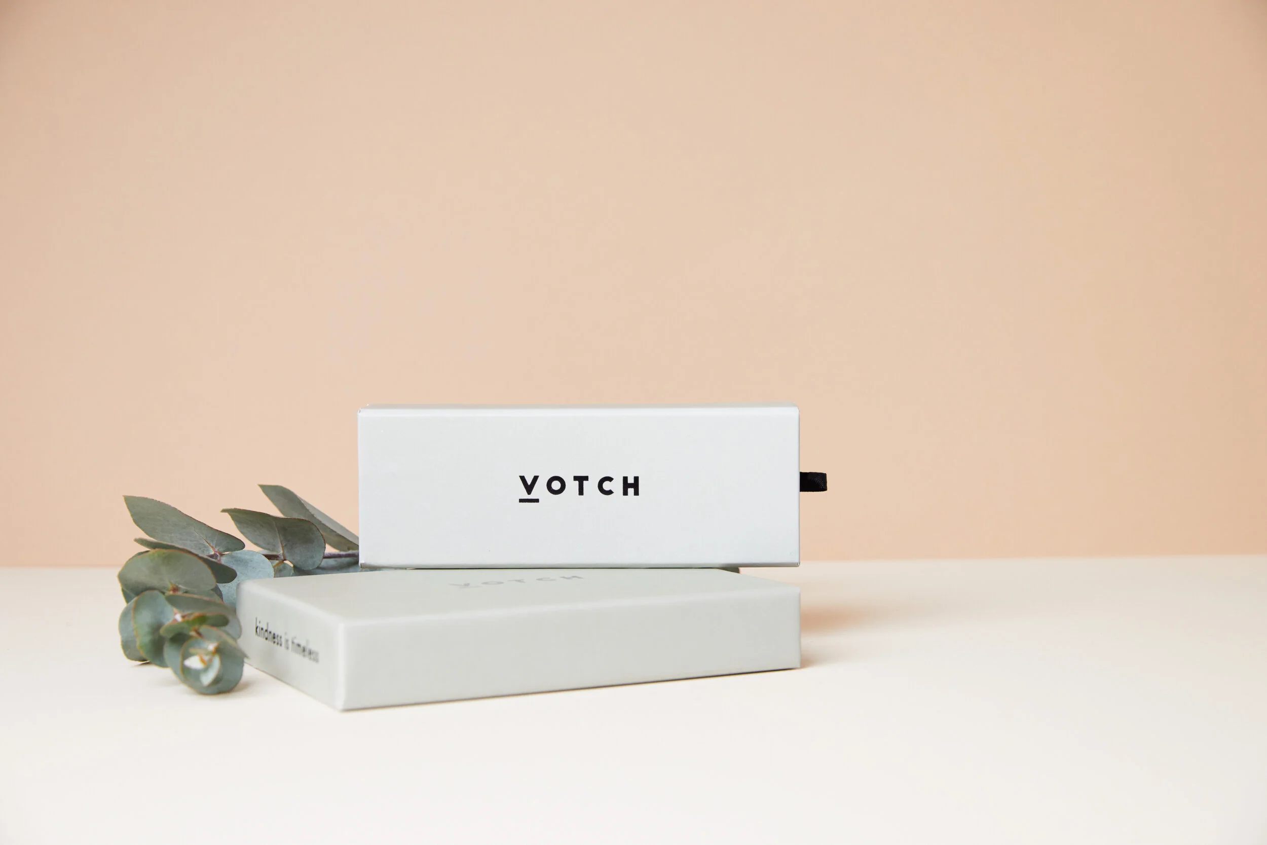 A white box labeled 'VOTCH' with a eucalyptus leaf, set against a light beige background.